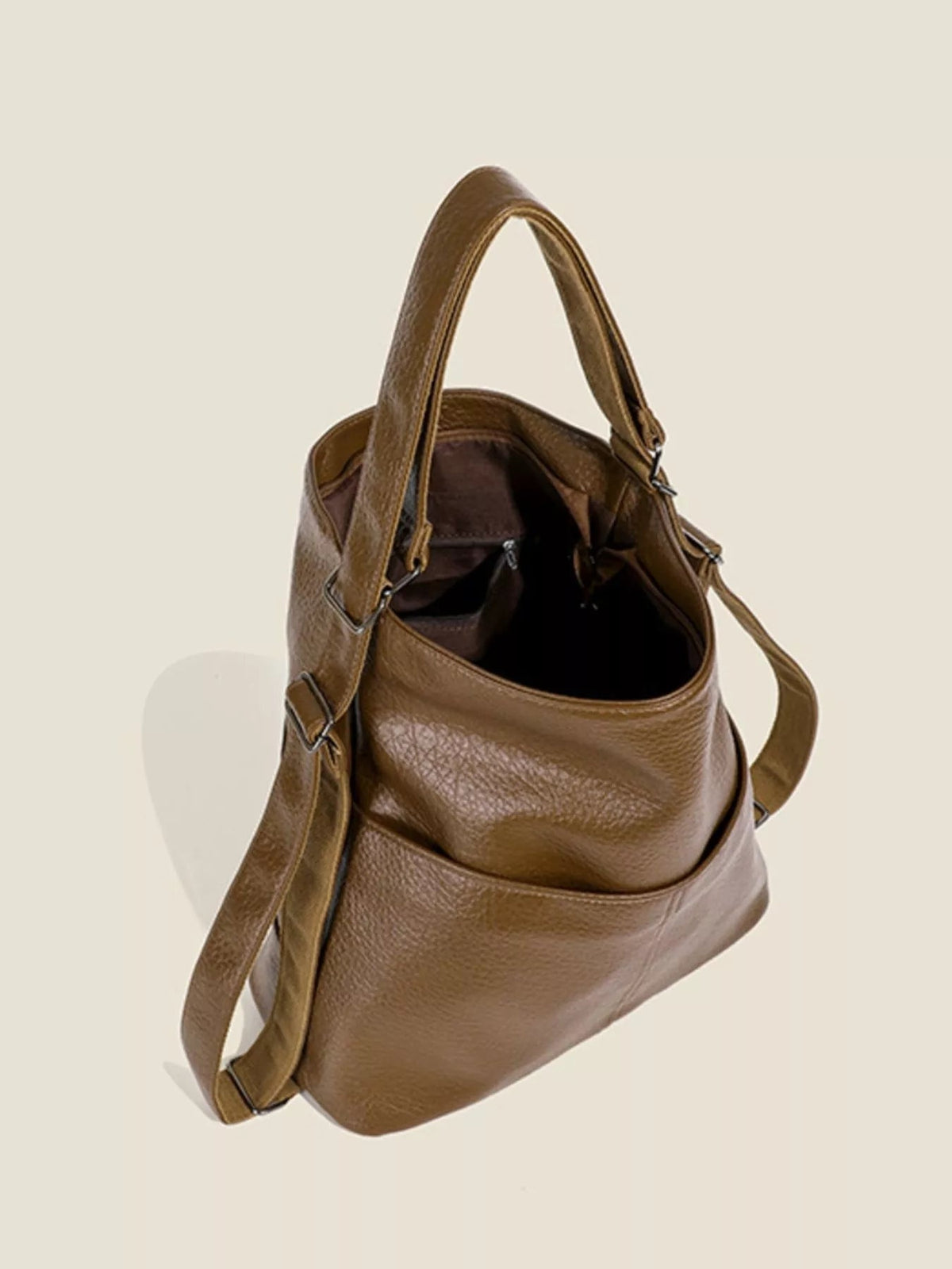 Medium brown PU leather convertible shoulder bag with a softly structured silhouette, dual top handles, long adjustable strap, and open compartment.