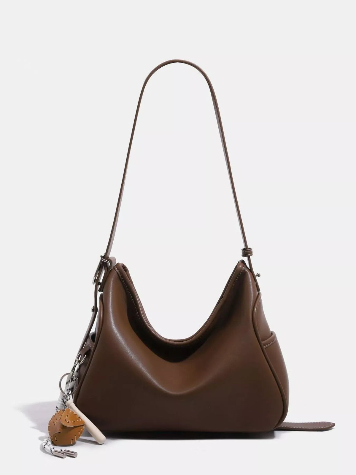 Medium brown PU leather slouchy shoulder bag with a long adjustable strap, softly curved silhouette, gathered sides, and a smooth structured base.