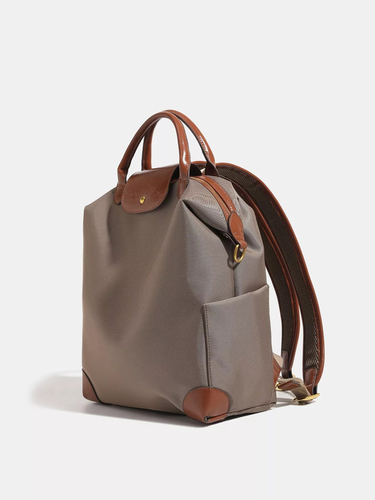Medium taupe nylon backpack with brown faux-leather trim, top handles, flap closure, zippered opening, front pocket, and padded shoulder straps.