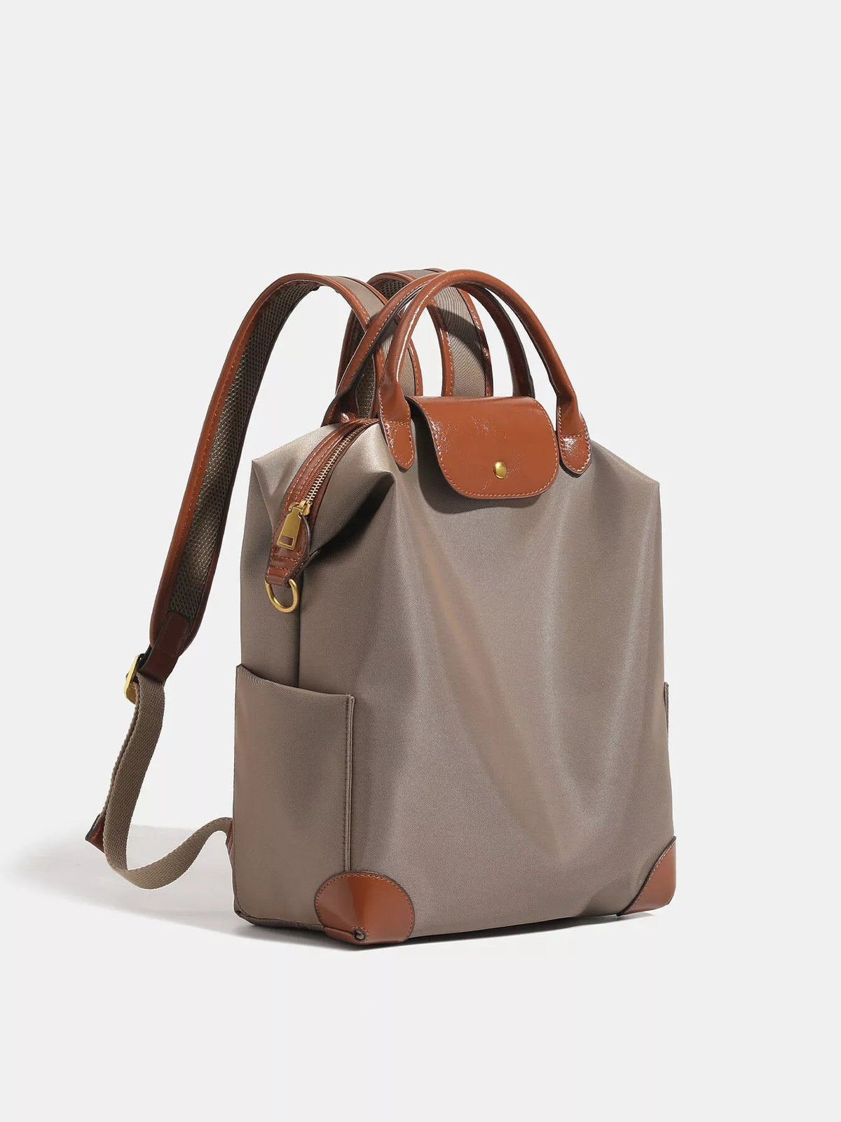 Medium taupe nylon backpack bag with brown faux leather trim, flap closure, padded adjustable shoulder straps, front pocket, and structured silhouette.