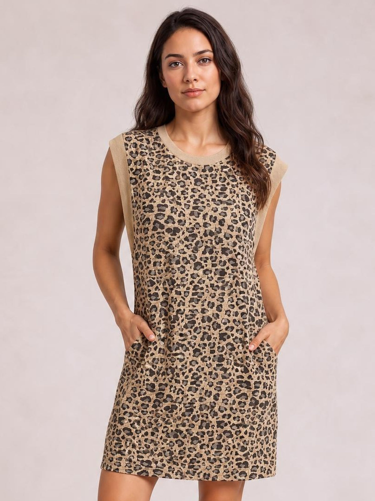 A model wears a tan and black leopard cap-sleeve mini dress with a round neckline, straight silhouette, and visible side pockets.