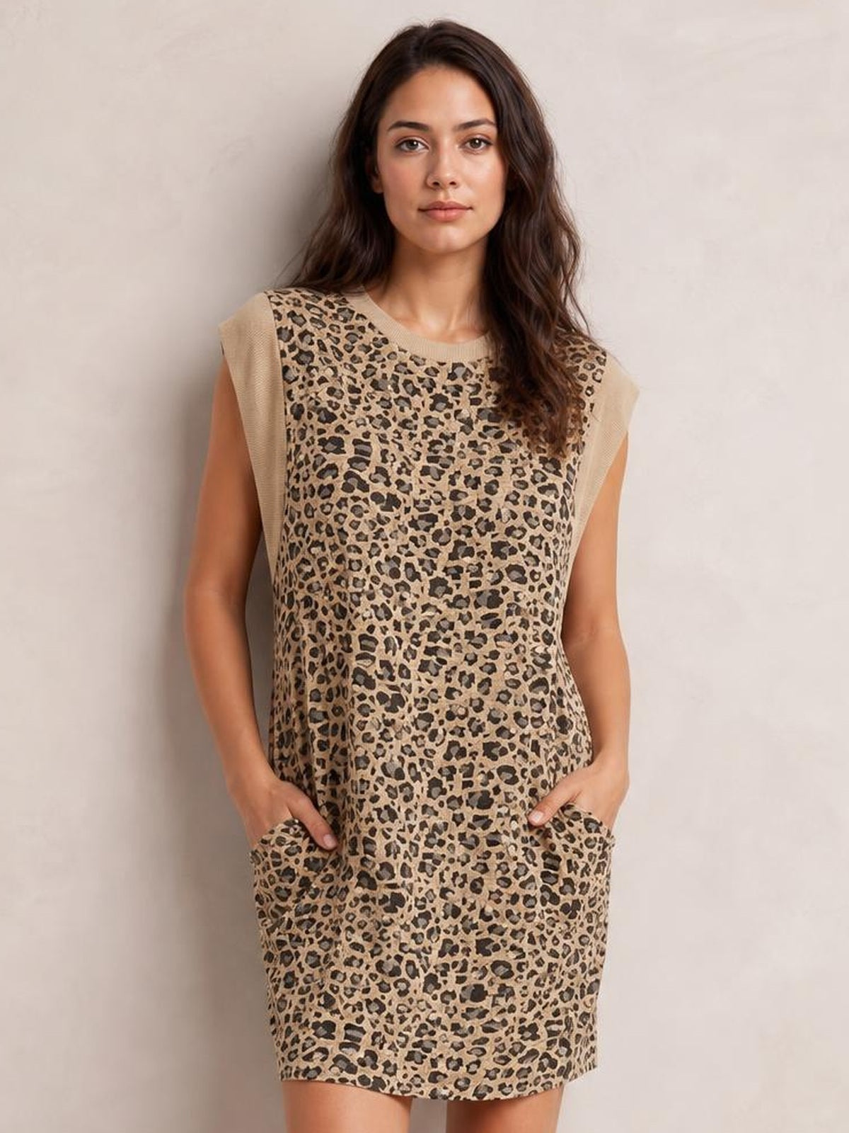 Model wears a tan and black leopard cap-sleeve mini dress with a round neckline, straight silhouette, and practical side pockets.