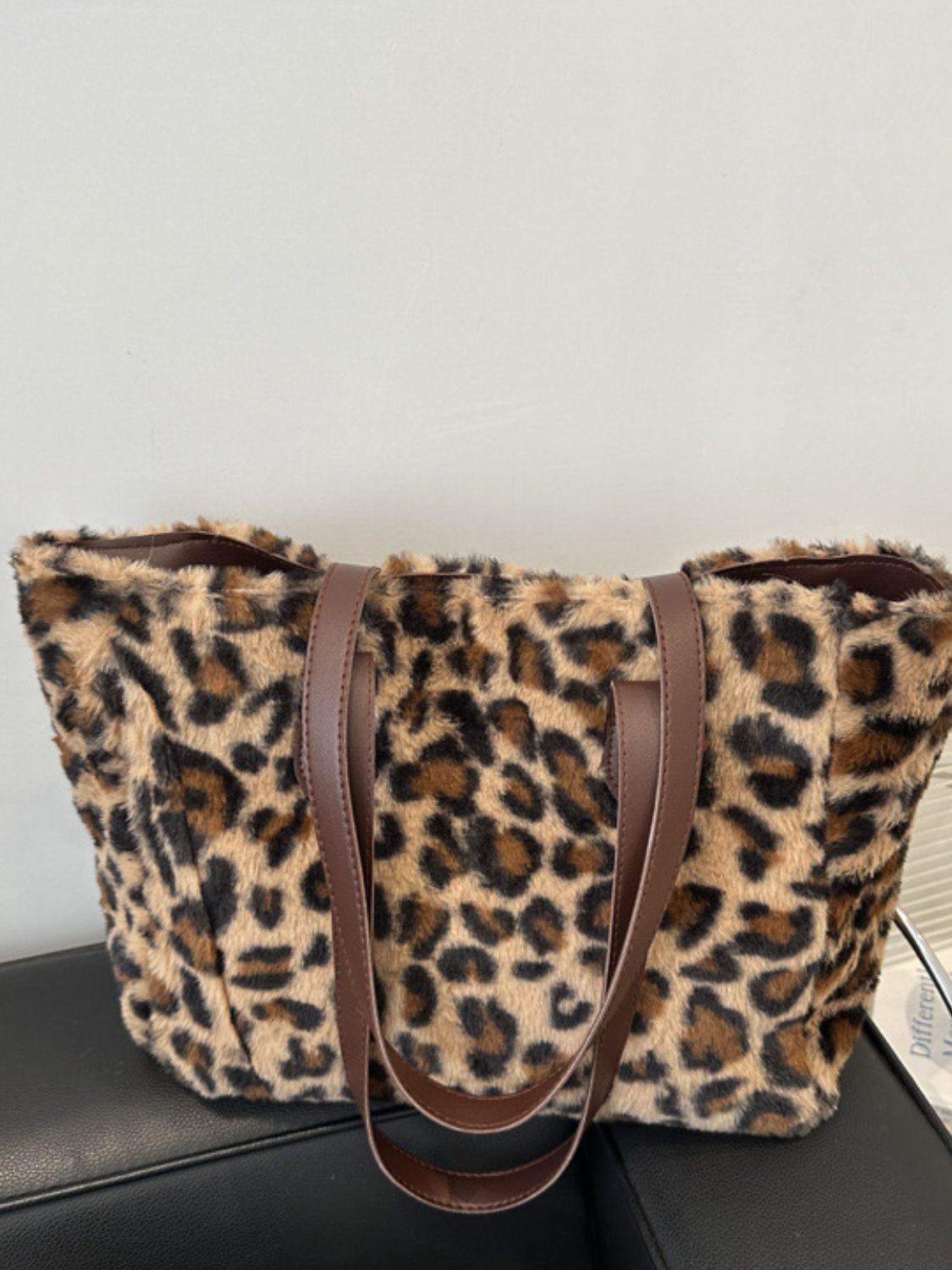 Leopard Fluff Tote Bag with a plush tan-and-black patterned exterior, softly structured silhouette, open top, and contrasting brown PU leather double handles.