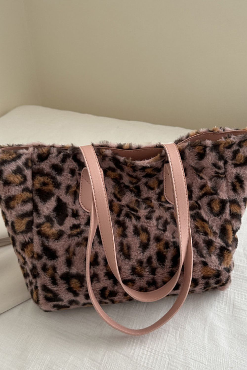 Leopard-print fluff tote bag in mauve brown and black features a softly structured silhouette, plush exterior, and long blush pink PU leather handles.