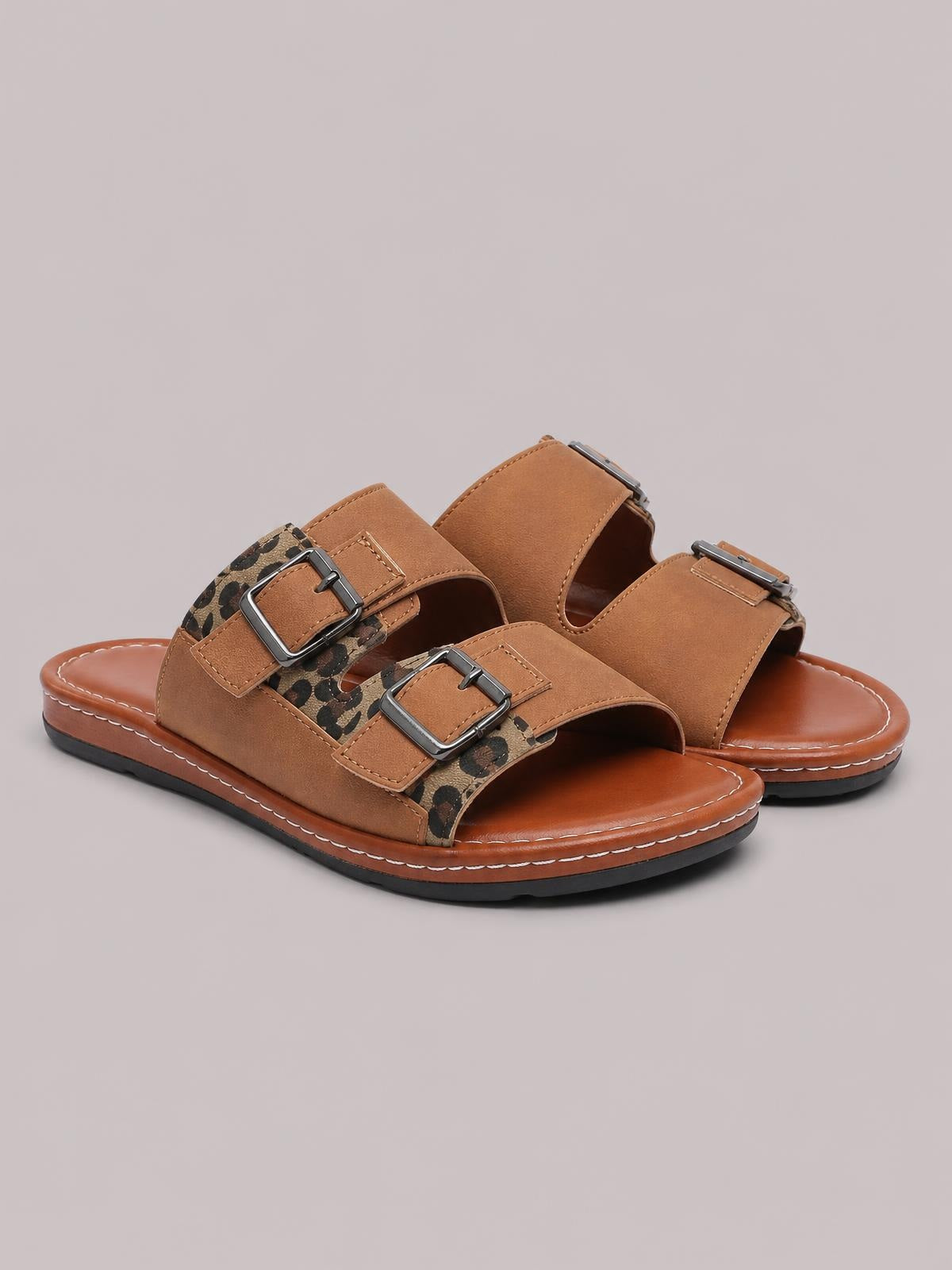 Brown leopard open toe flat sandals with two wide adjustable buckle straps, contrast stitching, cushioned soles, and sturdy rubber outsoles.