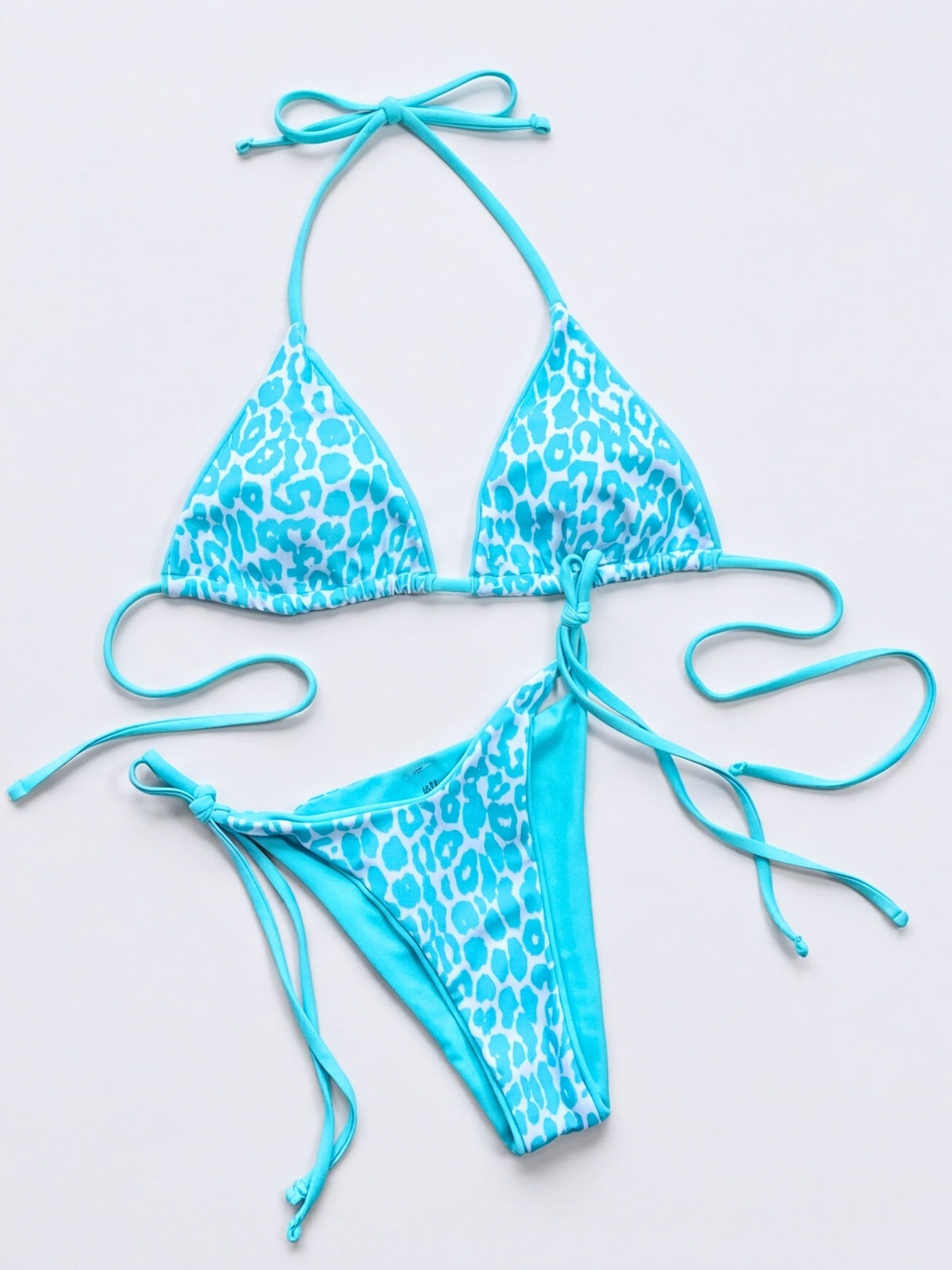 Turquoise leopard print bikini set laid flat, featuring a triangle halter top and matching tie-side bottoms with adjustable string straps.