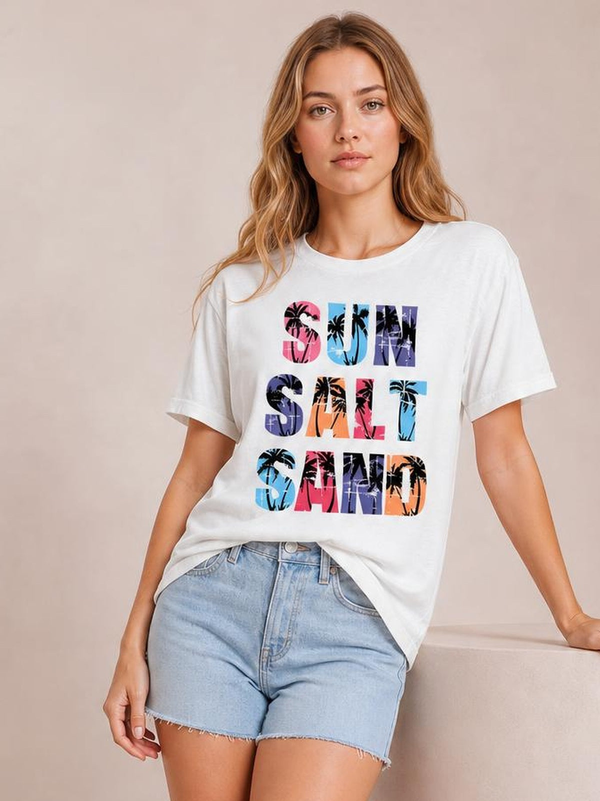 Model wearing a white Letter Graphic Round Neck Tee with colorful palm-print text, regular short sleeves, and a relaxed regular-length silhouette.