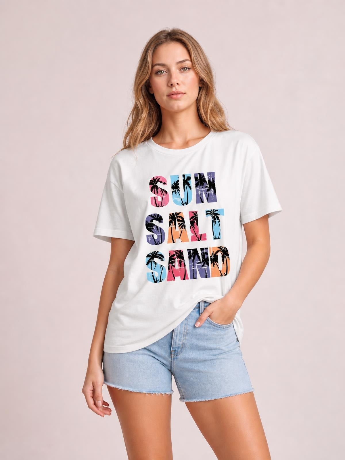 Model poses in a white Letter Graphic Round Neck Tee with short sleeves, regular-length silhouette, and colorful “SUN SALT SAND” print.