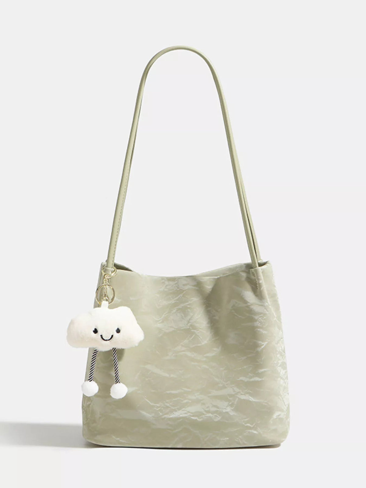 Medium lightweight PU leather shoulder bag in pale green with a long strap, softly structured silhouette, crinkled texture, and a playful cloud charm.