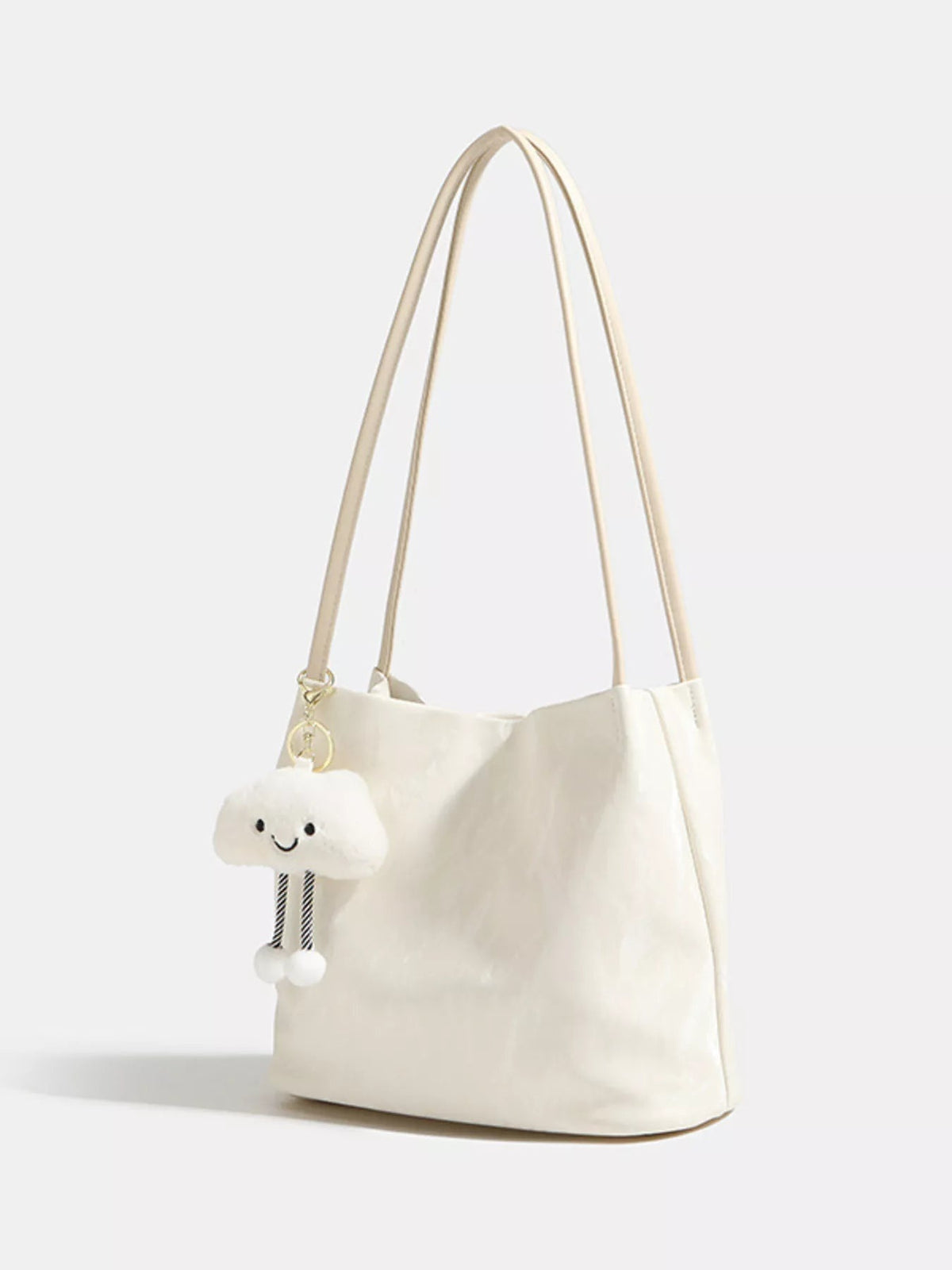 Cream medium PU leather shoulder bag with a relaxed tote silhouette, long double straps, softly structured sides, and a playful cloud charm.