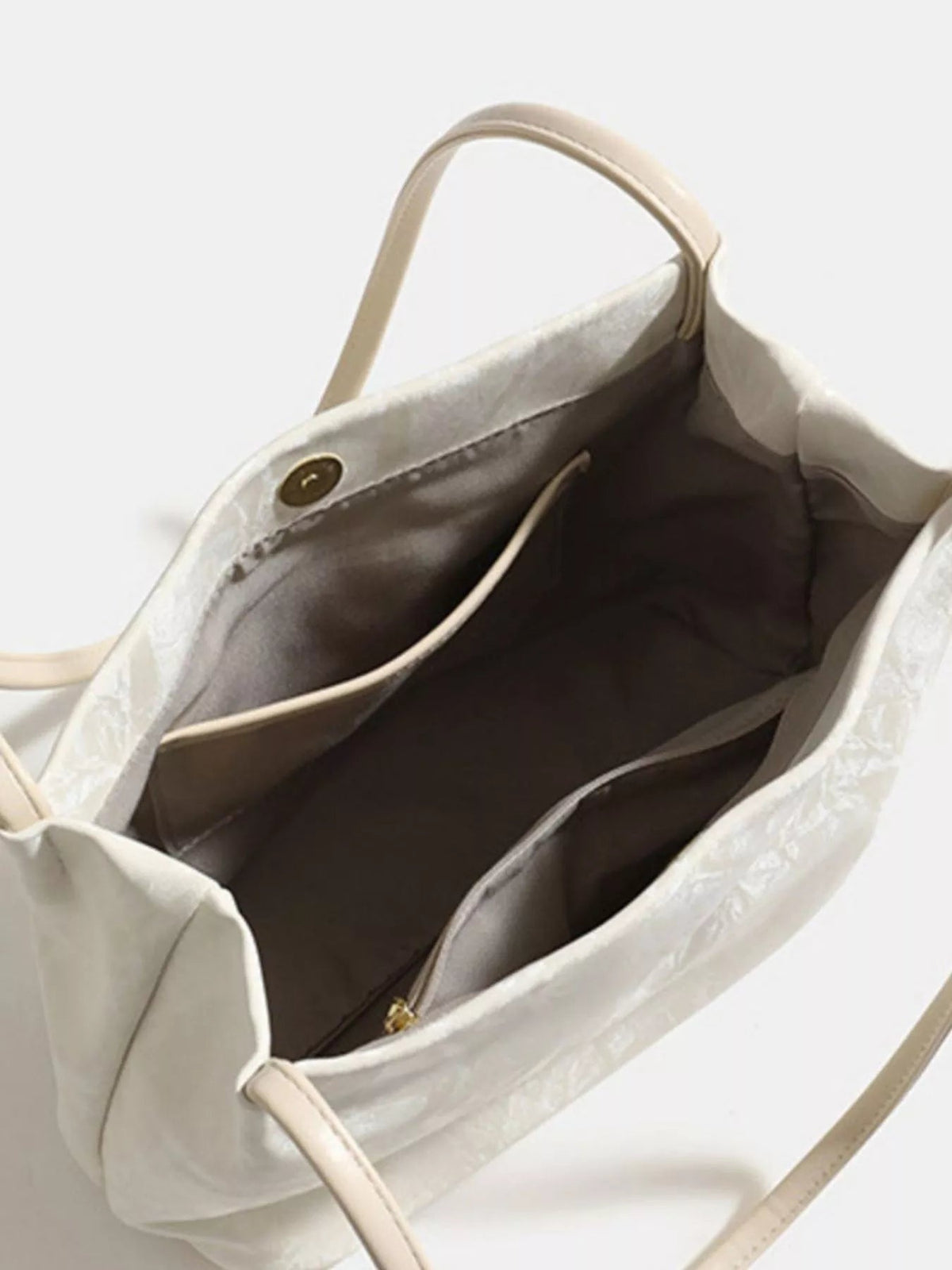 Open medium cream PU leather shoulder bag showing a spacious dark-lined interior, inner zip pocket, magnetic snap closure, and slim shoulder strap.