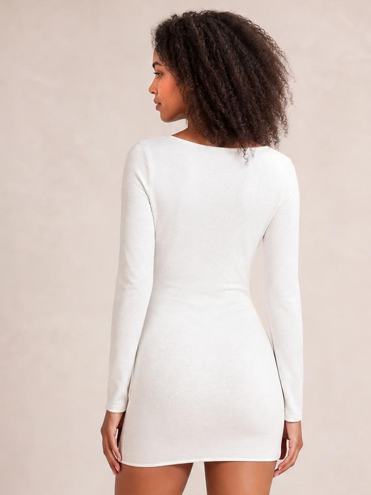 Model shown from the back in a white long-sleeve bodycon mini dress with a fitted silhouette, smooth construction, and straight mini hem.