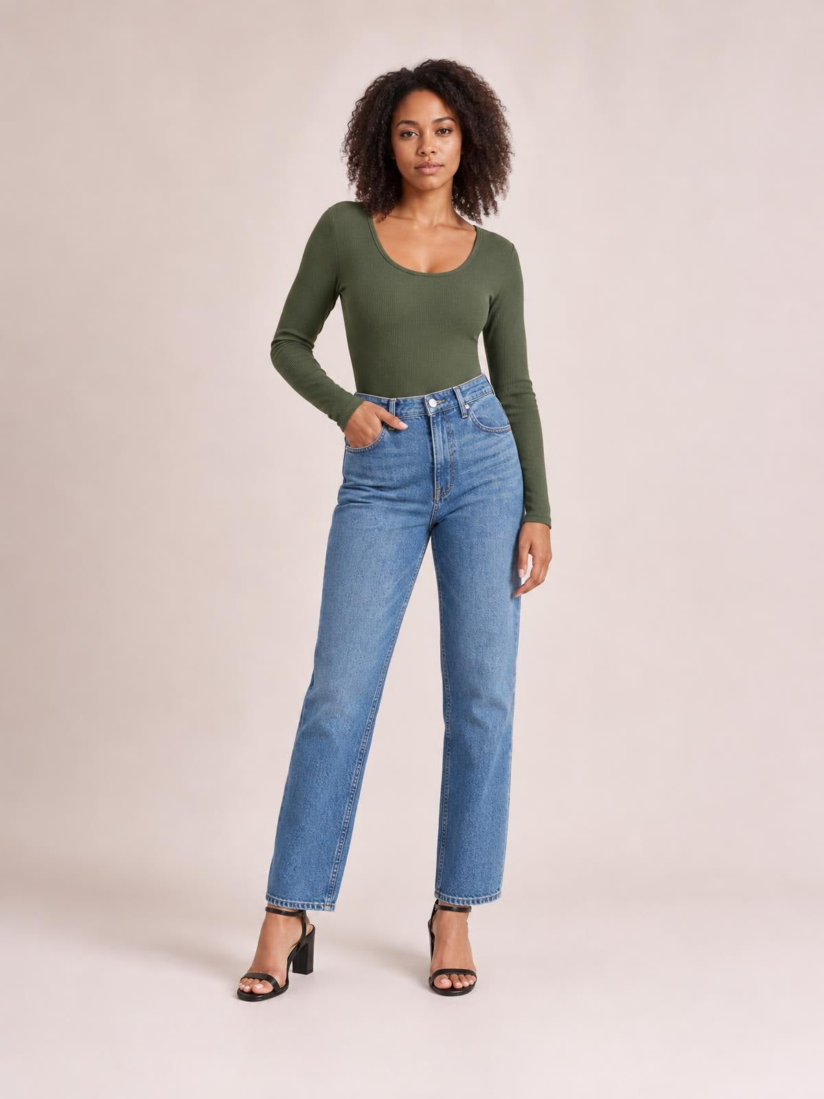 Model stands in a relaxed pose wearing an olive green long sleeve scoop neck T-shirt with a close-fitting silhouette and ribbed construction.