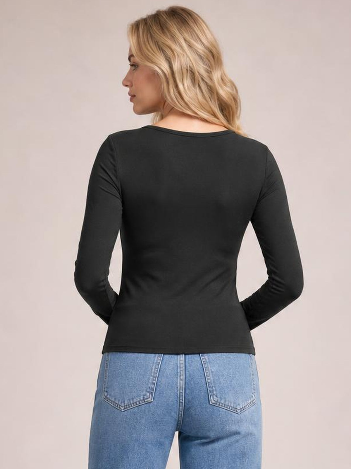 Model turned away in a black long sleeve scoop neck T-shirt with a smooth fitted silhouette and clean hem, paired with light blue jeans.