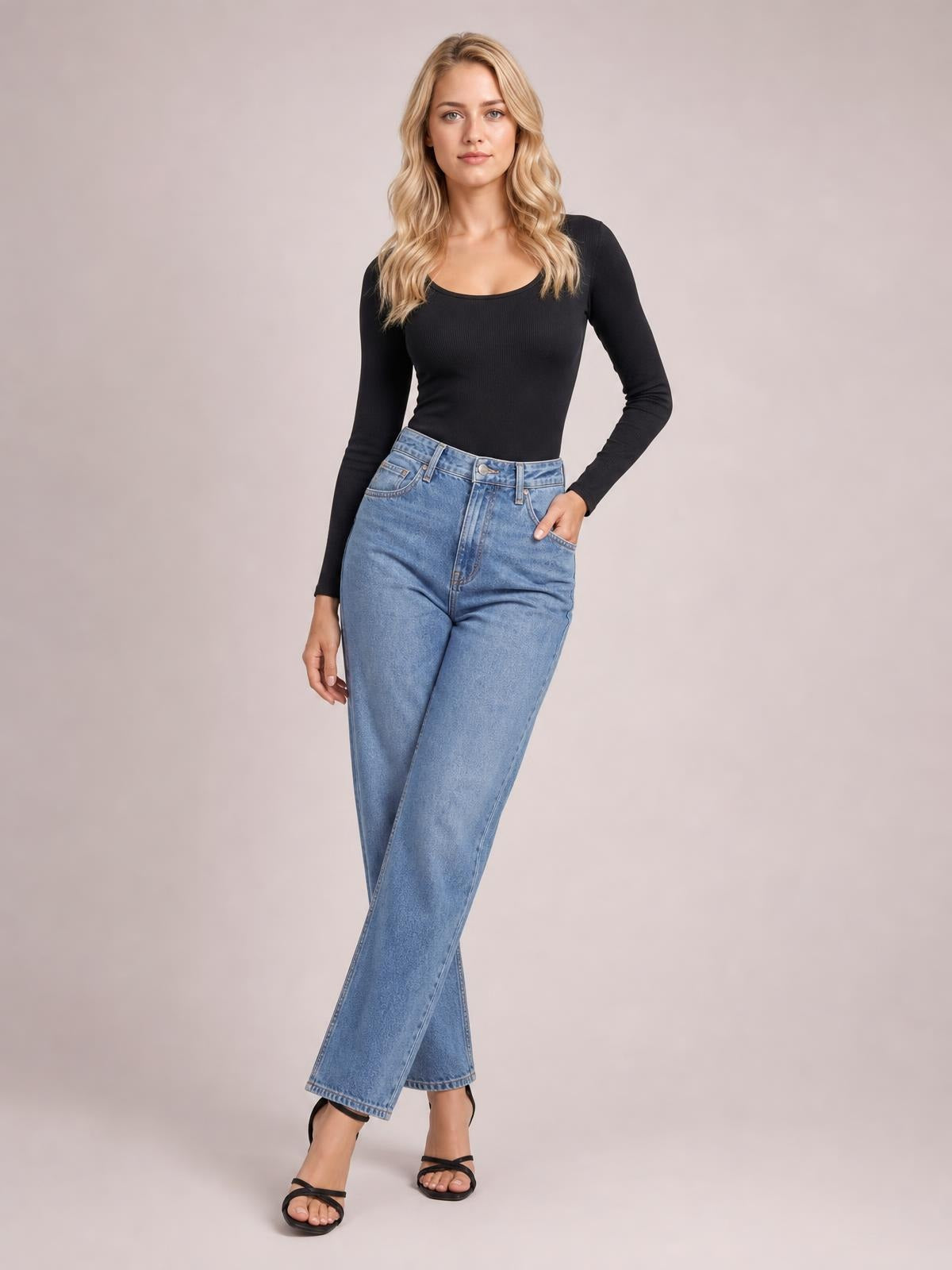 A model poses in a fitted black long sleeve scoop neck T-shirt with a smooth, stretchy silhouette and simple construction.