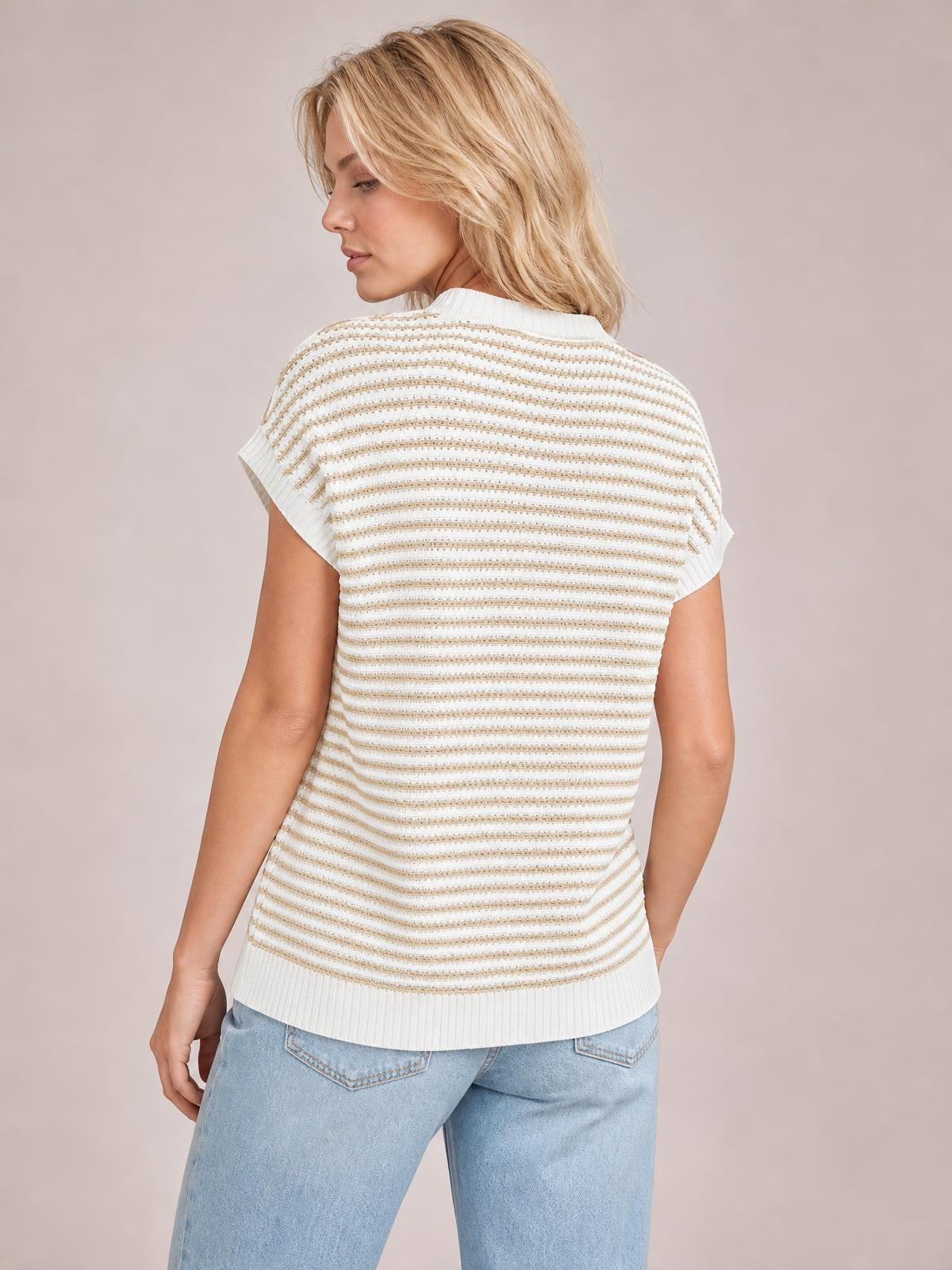 Model poses in profile wearing a white striped round-neck sweater with ribbed cap sleeves, a relaxed straight silhouette, and ribbed hem.