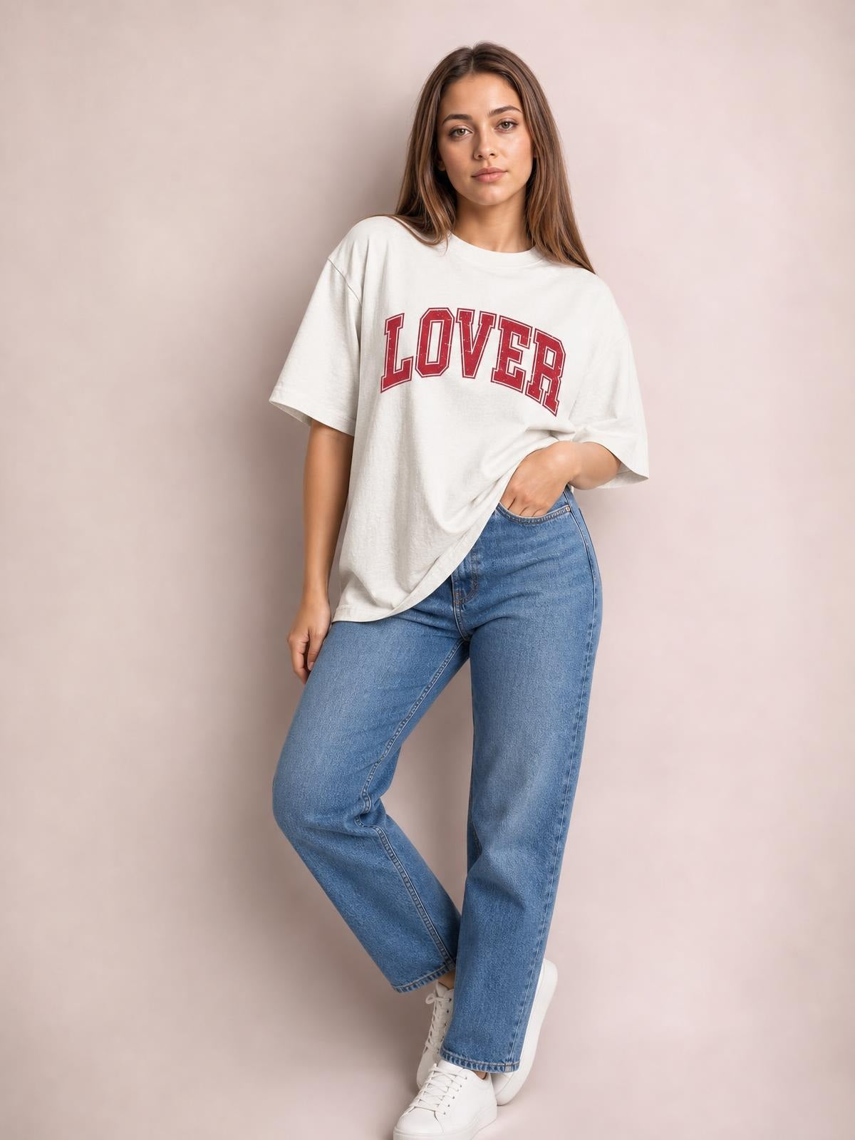 Model poses in an oversized white round neck half sleeve T-shirt with red “LOVER” lettering, a relaxed silhouette, and slightly dropped shoulders.