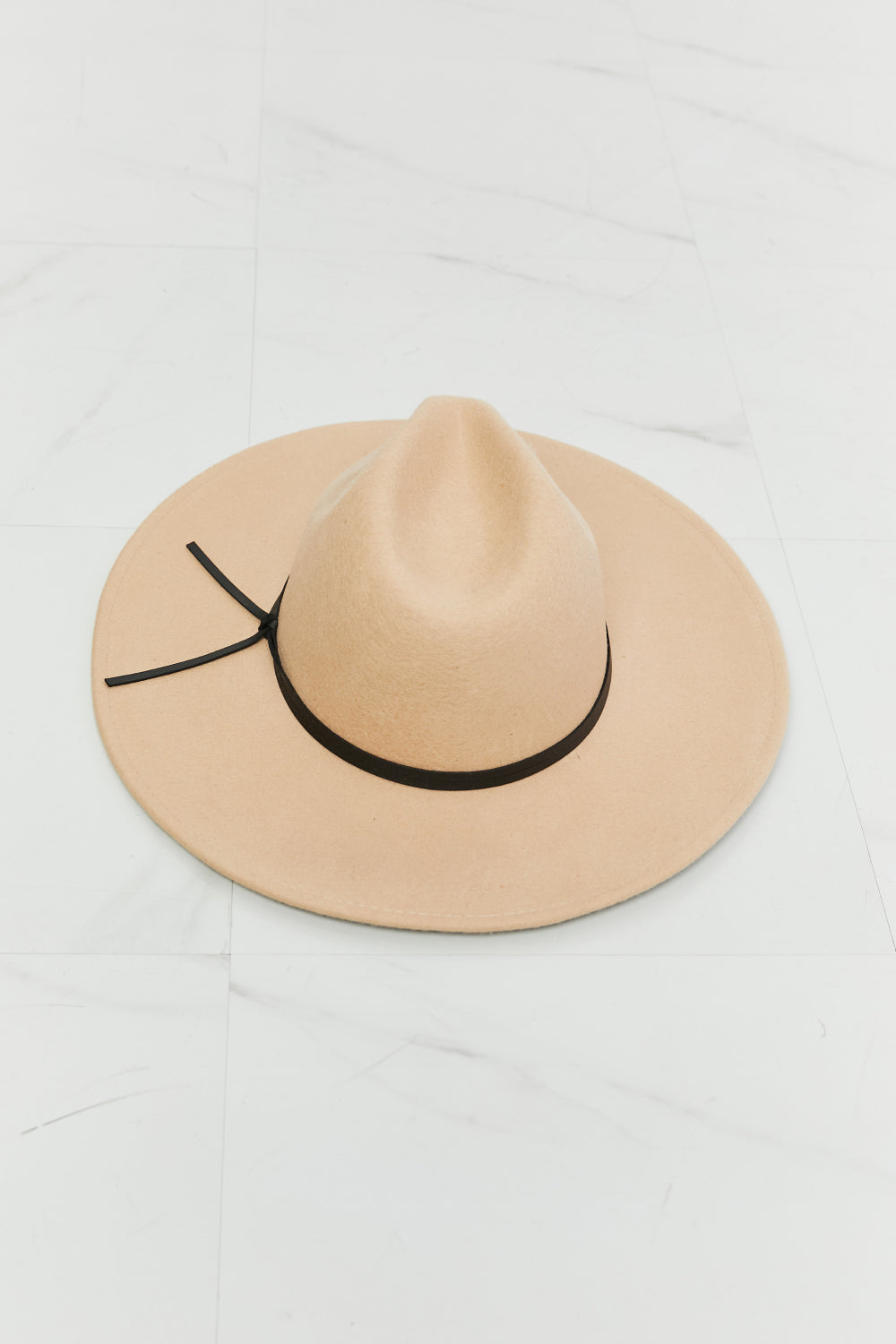 Beige fedora hat with a softly structured crown, generous 3.5-inch brim, contrasting black band, and tied detail at the back.