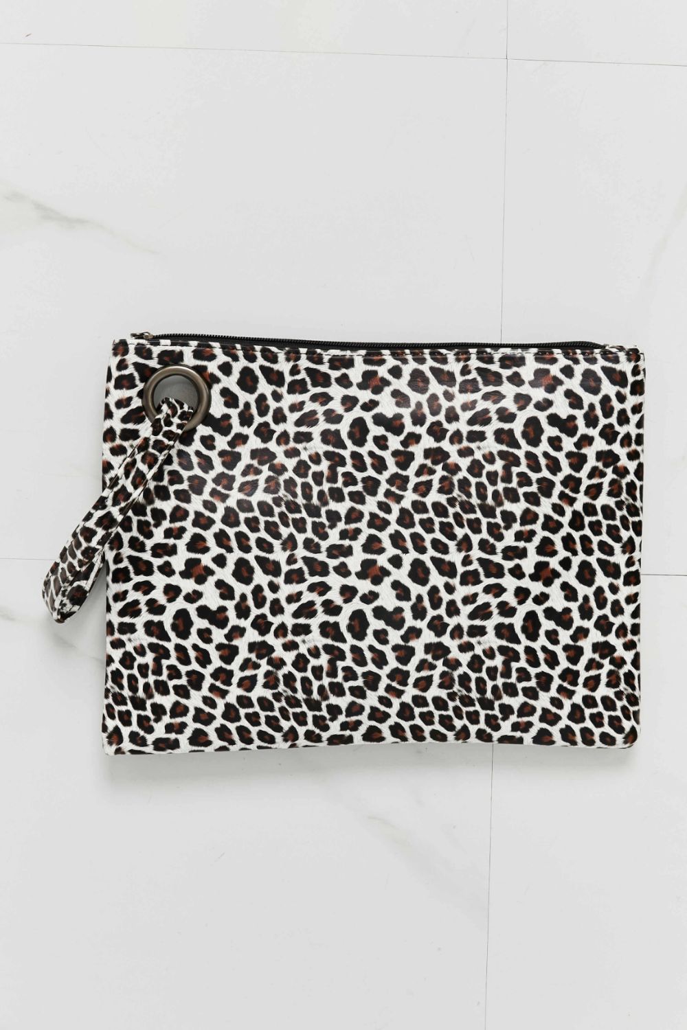 A medium printed wristlet in leopard-print PU leather features a clean rectangular silhouette, top zip closure, and attached wrist strap.
