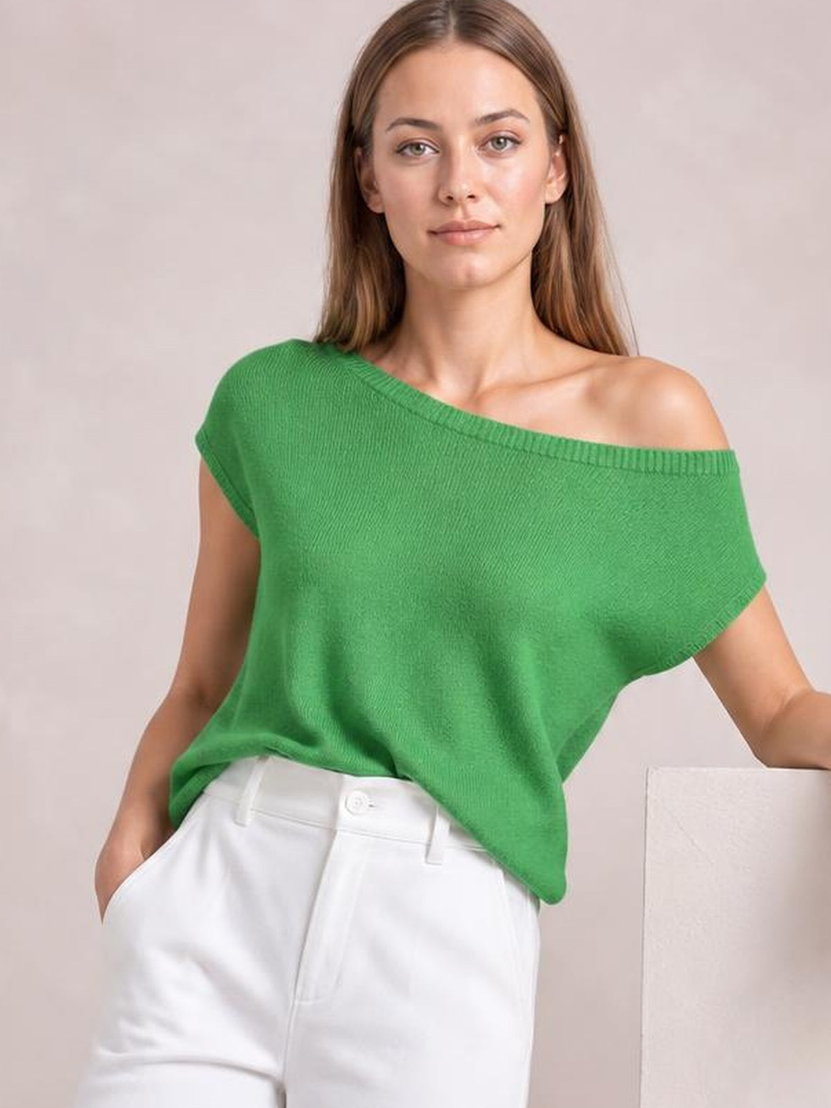 Model wearing a bright green boat neck short sleeve knit top with a relaxed silhouette, wide neckline, and ribbed neckline and sleeve edges.