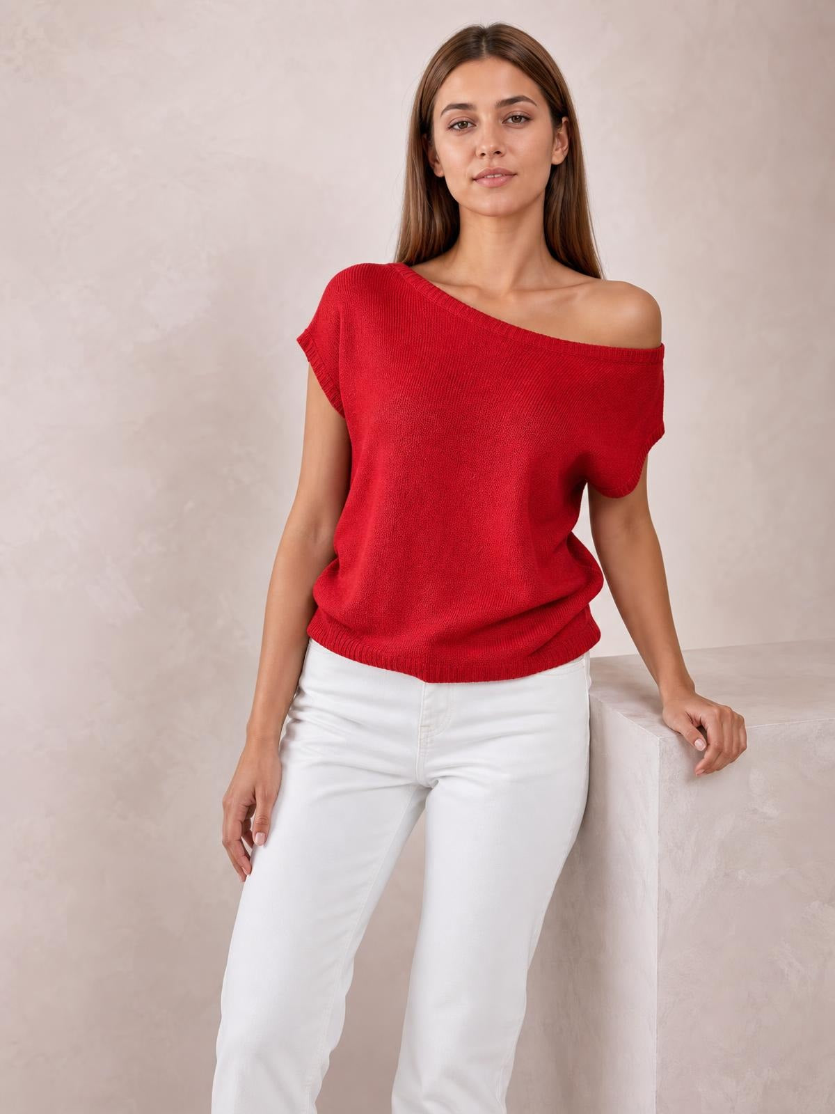 Model wearing a red boat neck short sleeve knit top with a relaxed silhouette, ribbed neckline and hem, paired with white pants.