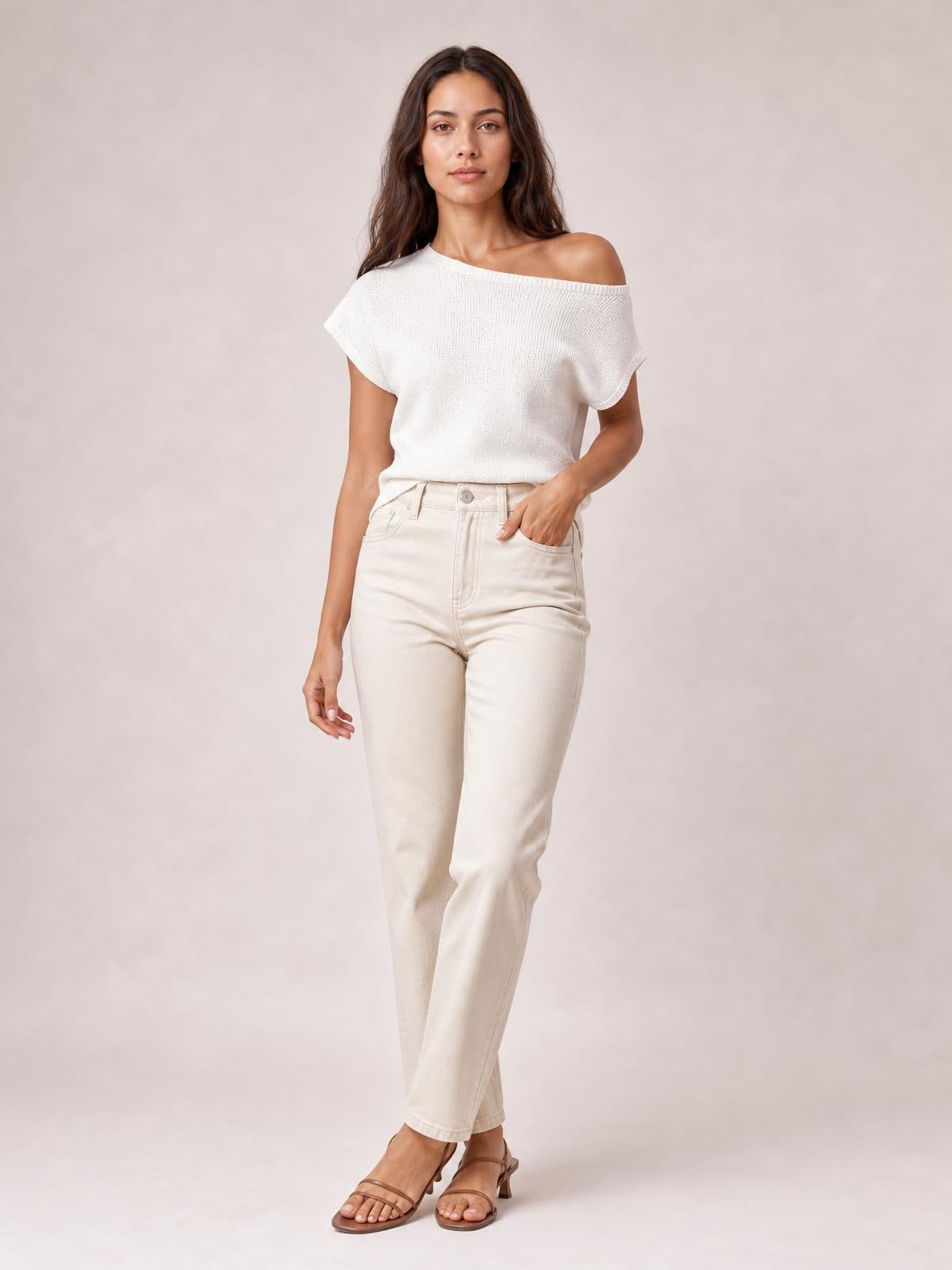 Model wears a white boat neck short sleeve knit top with a relaxed silhouette and ribbed construction, tucked into high-waisted cream pants.