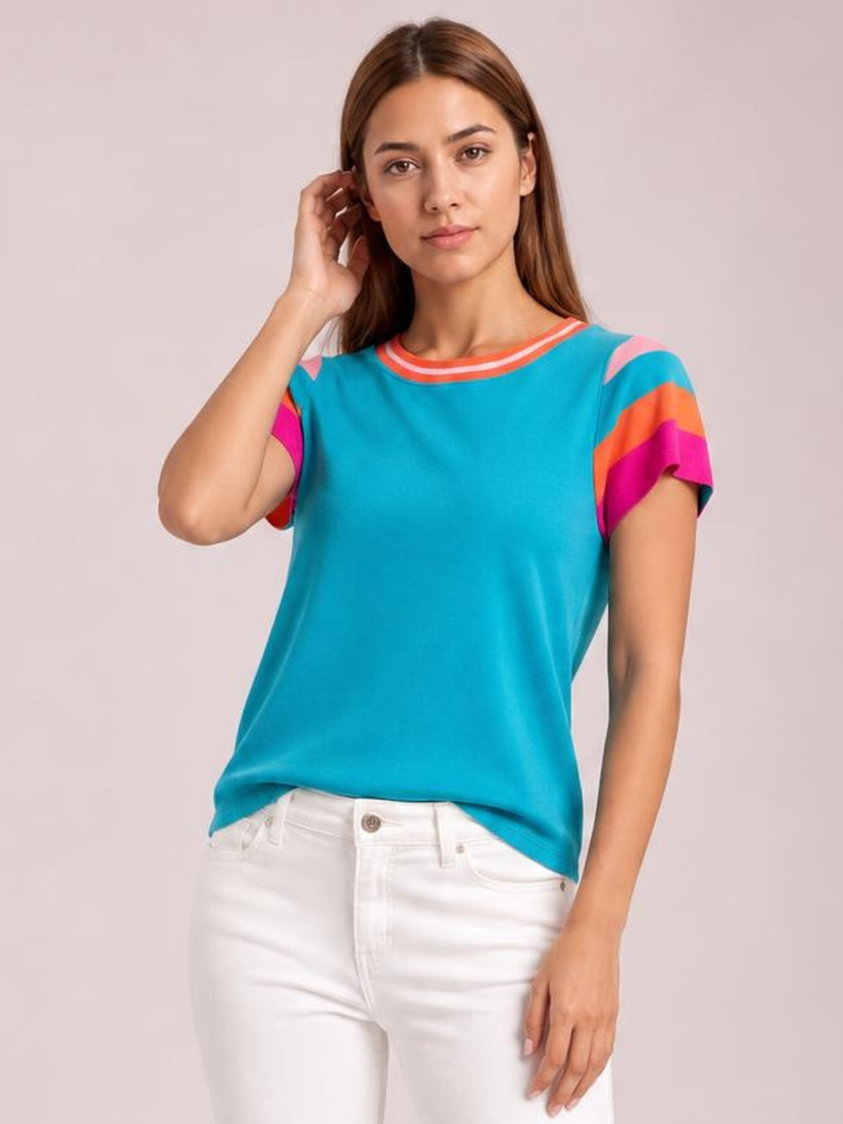A model poses with one hand near her hair, wearing a turquoise knit top with a round contrast neckline, short striped sleeves, and a relaxed straight silhouette.