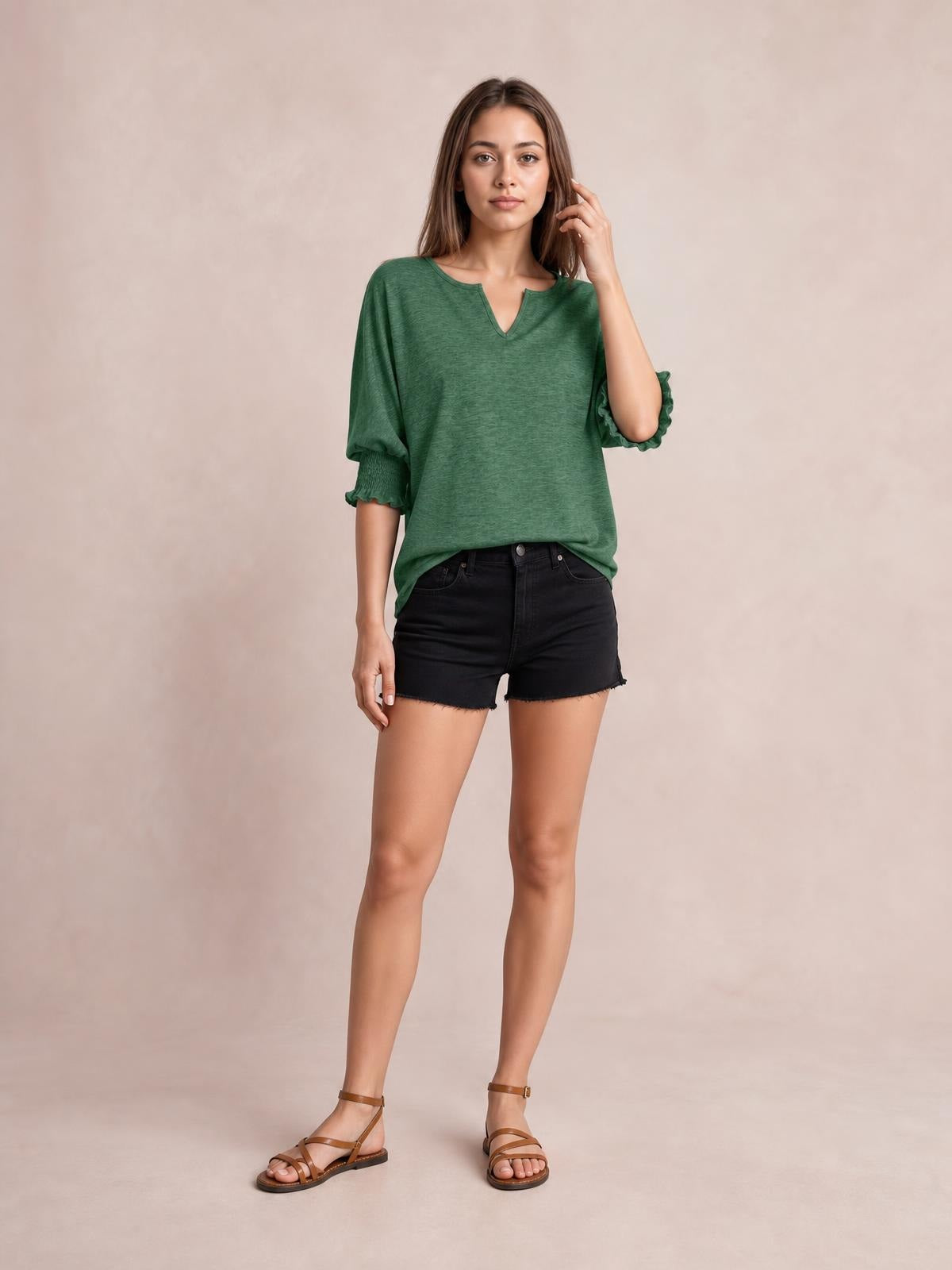 Model poses in a green heathered blouse with a notched neckline, loose lantern sleeves, and frill-trimmed cuffs.