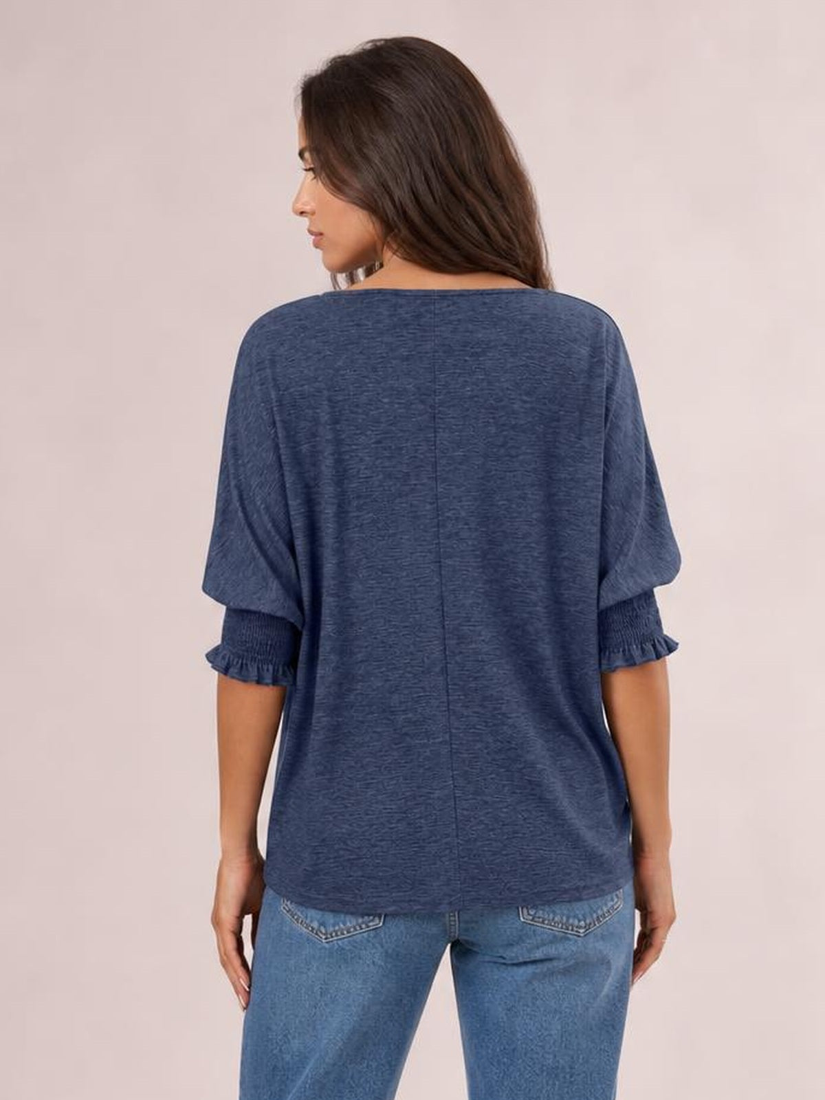A model turns slightly to show a blue heathered blouse with a relaxed silhouette, center-back seam, lantern sleeves, and frill-trimmed cuffs.