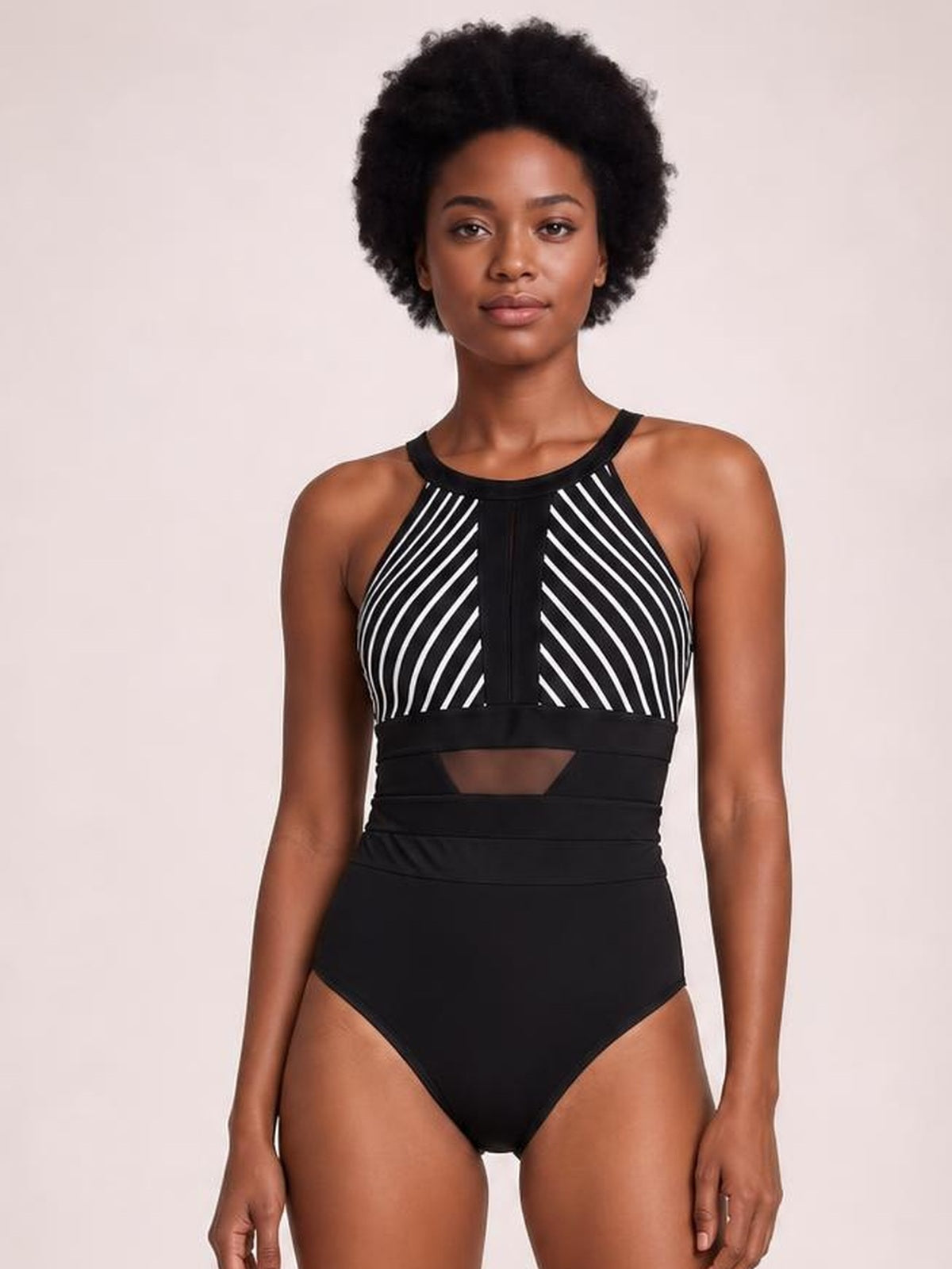 A model stands front-facing in a black and white striped one-piece swimsuit with a high neckline, mesh detail, waist cutout, and high-leg silhouette.