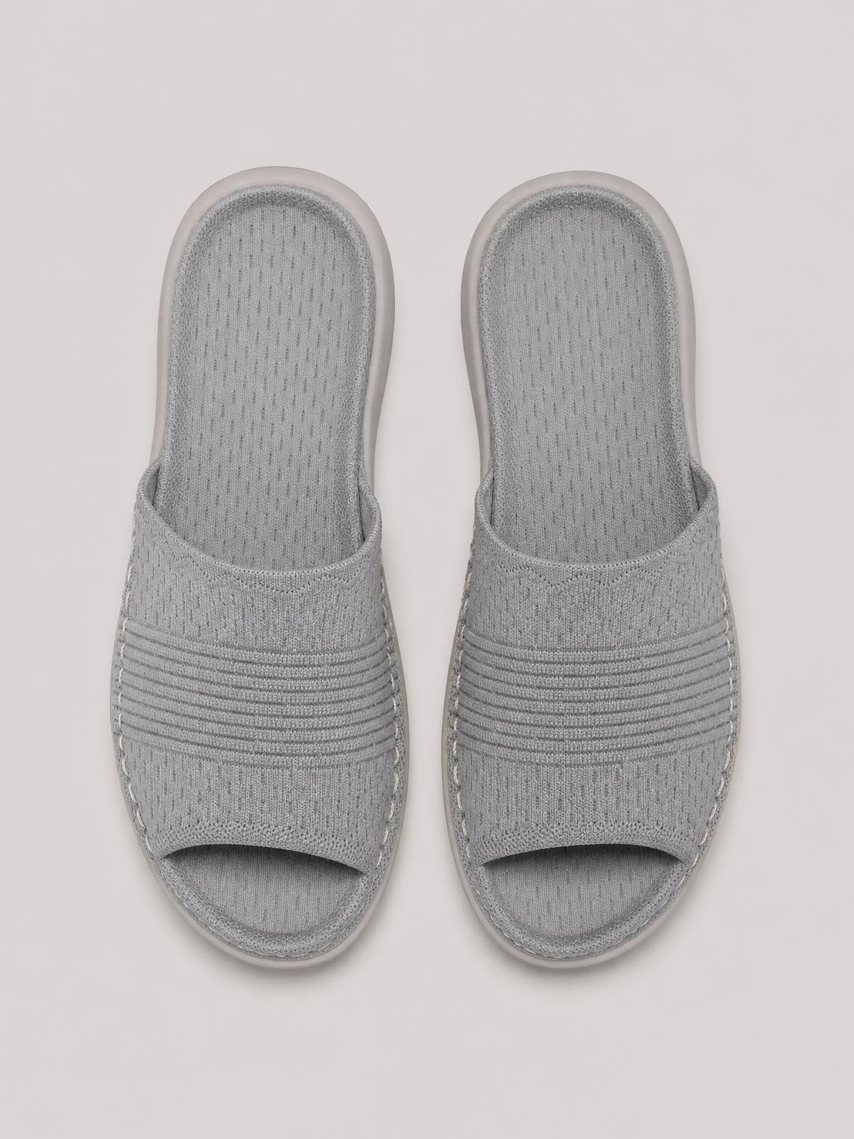 Light gray mesh open-toe flat sandals feature breathable knit uppers, wide textured straps, rounded toes, and flexible rubber soles.