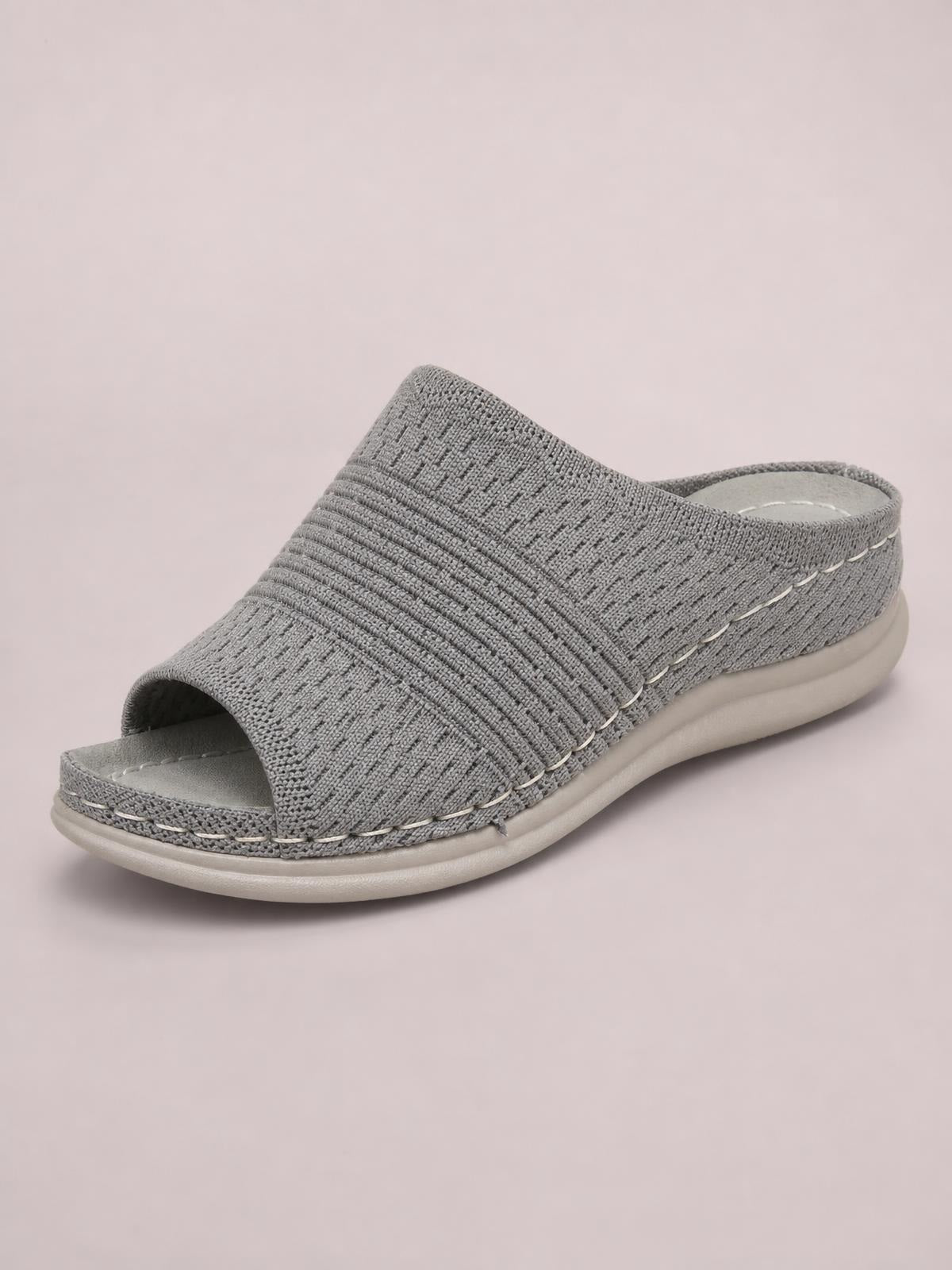 Gray mesh open-toe flat sandal with a wide woven slip-on upper, stitched trim, cushioned footbed, and rubber sole.