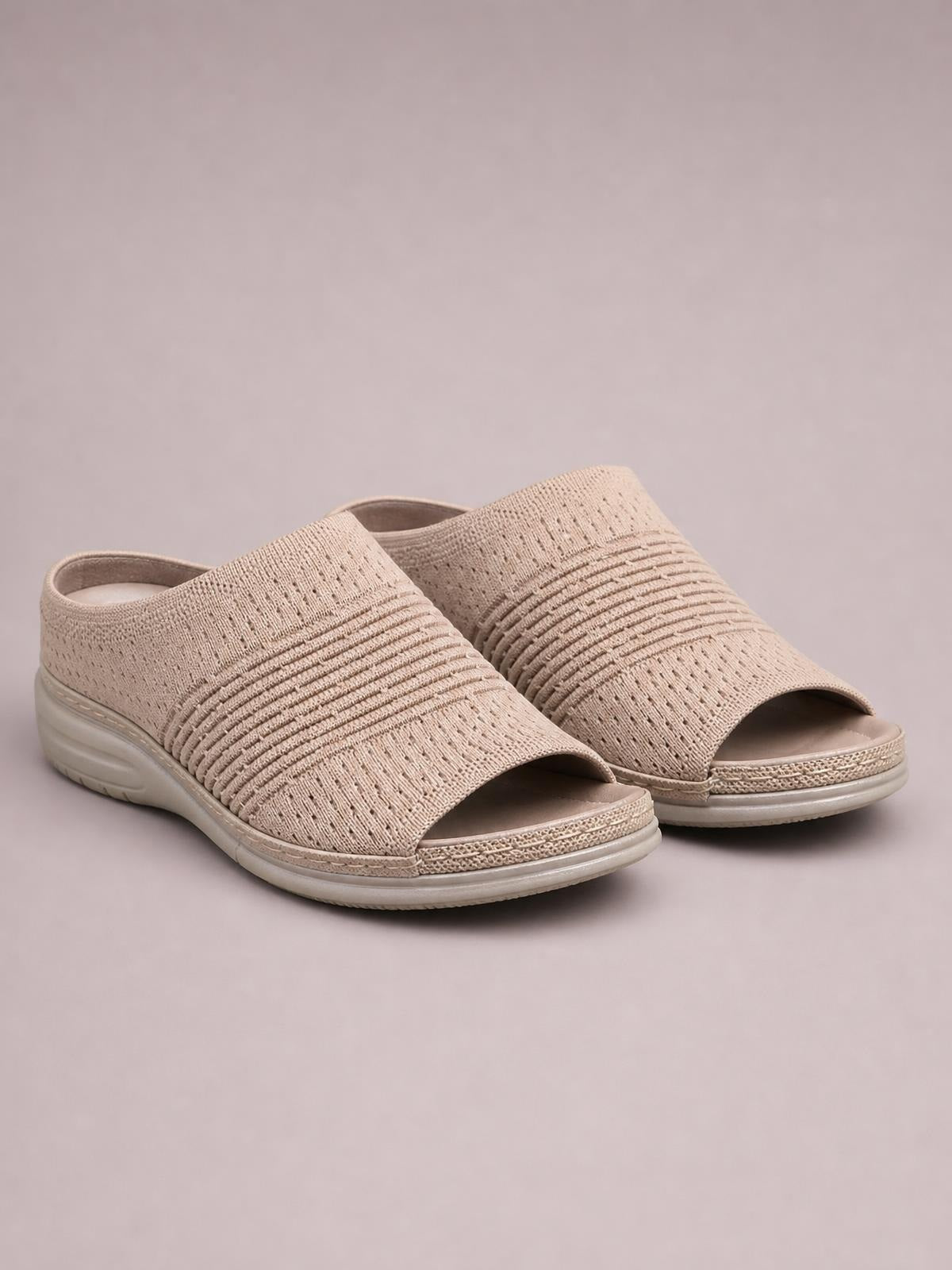 Beige mesh open-toe sandals with textured woven uppers, wide straps, cushioned flat wedge soles, and rounded toes.