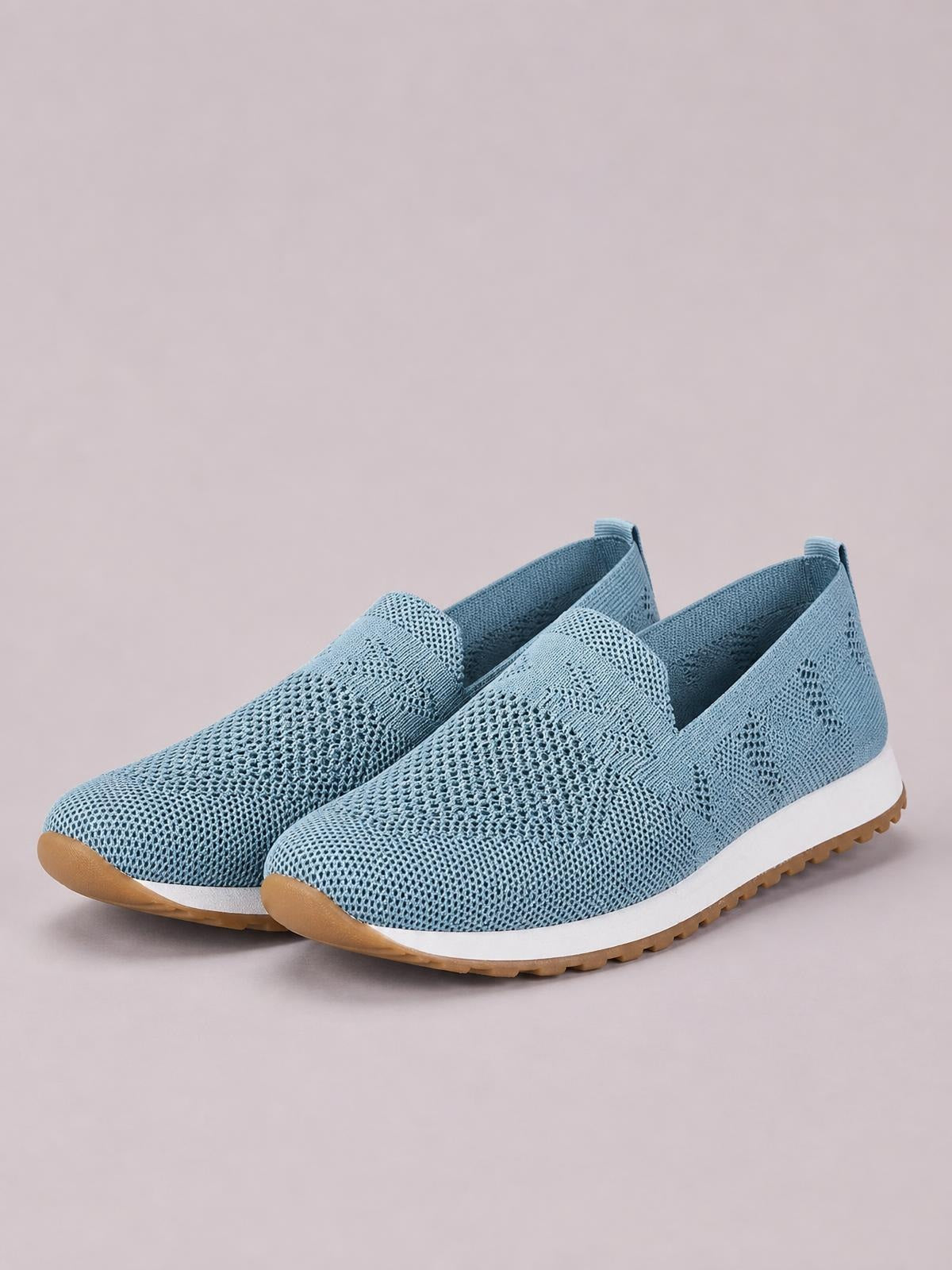 Light blue mesh round-toe flat slip-ons feature a breathable knit upper, low-cut opening, white midsoles, and textured tan rubber outsoles.