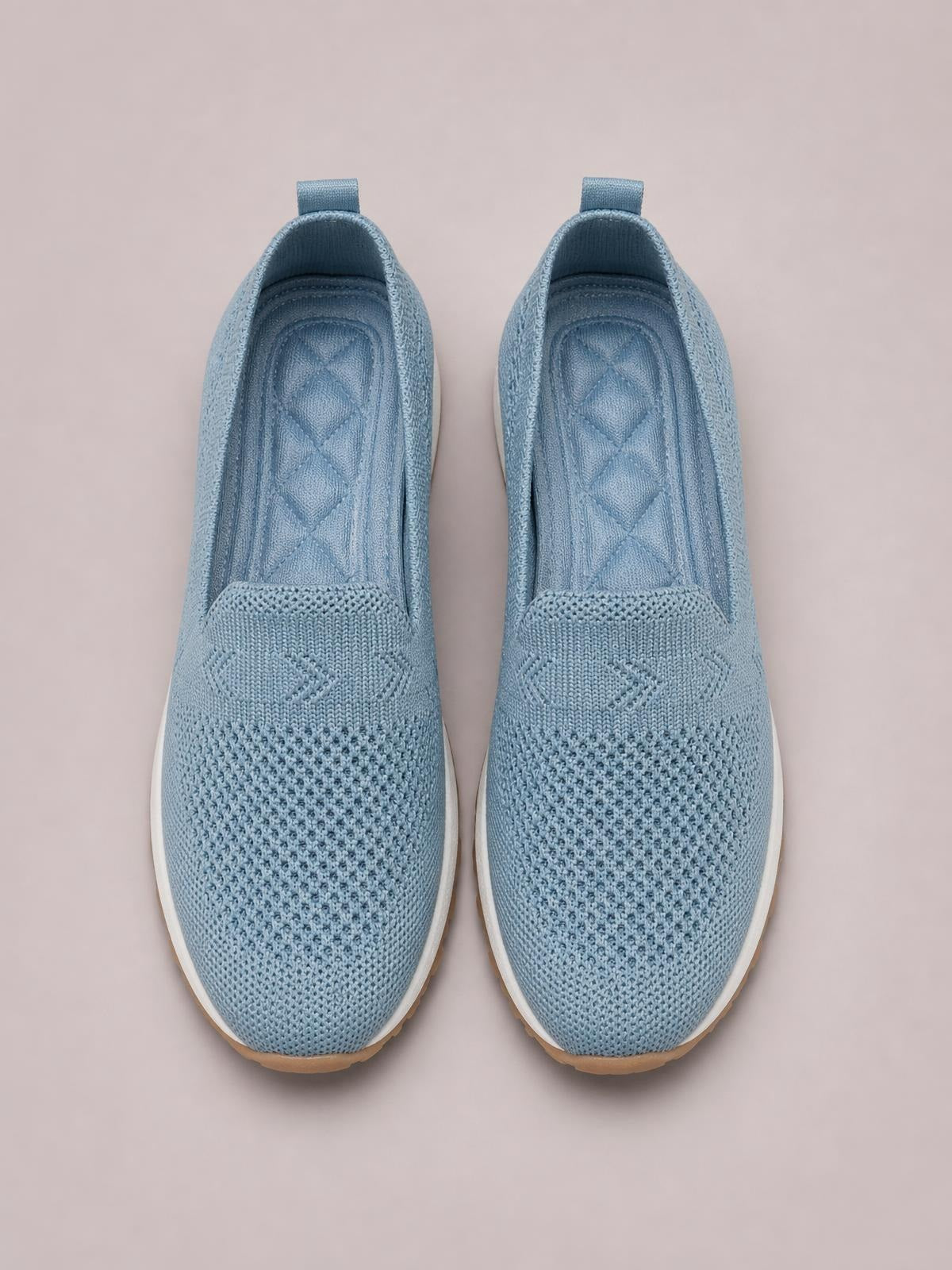 Blue mesh round-toe flat slip-ons feature a breathable knit upper, cushioned insole, pull tabs, and contrasting rubber soles.
