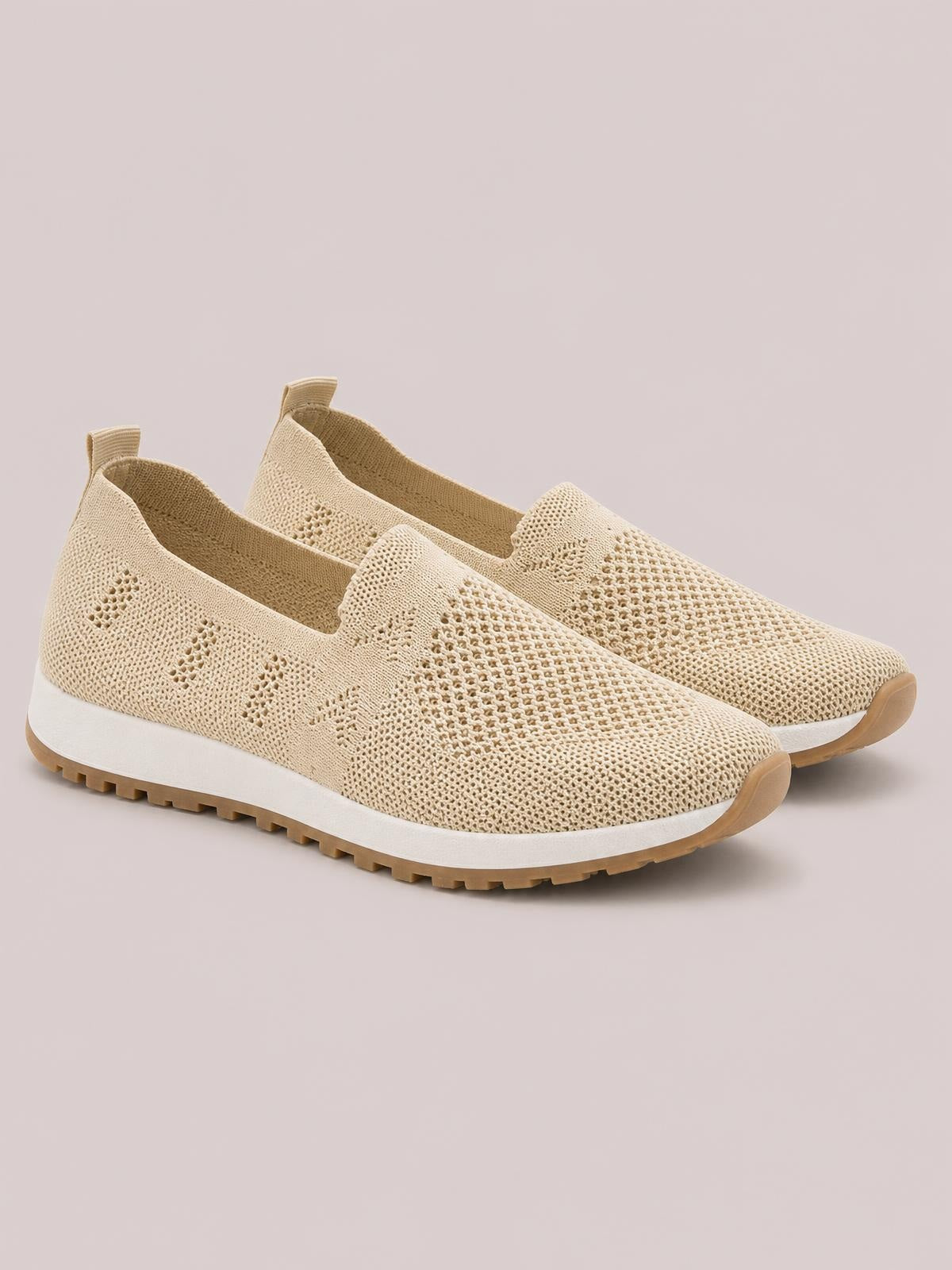 Beige mesh round-toe flat slip-ons feature breathable perforated uppers, easy pull tabs, thick white midsoles, and tan rubber treaded outsoles.