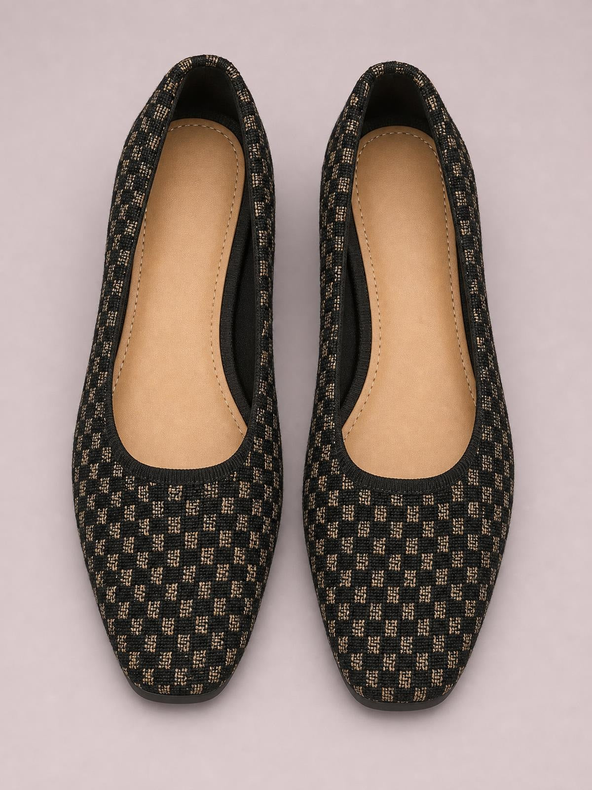 Black and beige patterned mesh round-toe flat slip-ons shown from above, featuring open slip-on construction, tan cushioned insoles, and slim rubber soles.