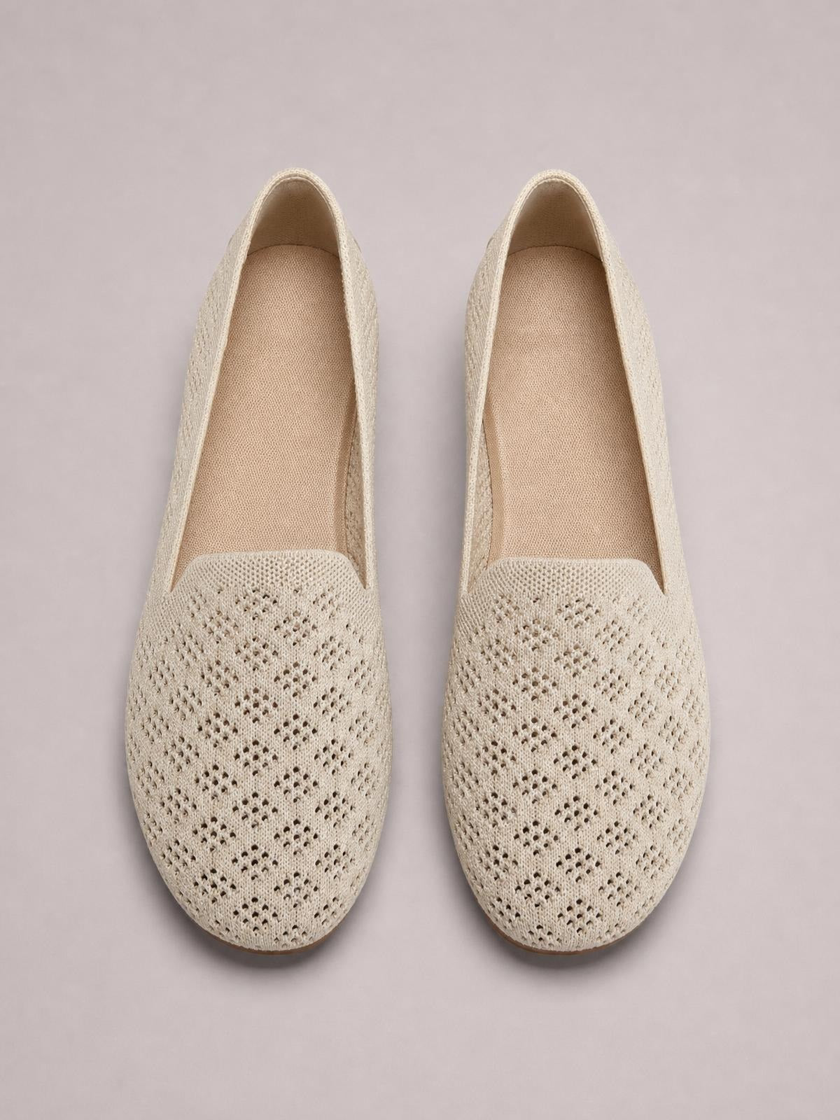 Cream mesh round-toe flat slip-ons with perforated uppers, low-profile silhouettes, and cushioned textile insoles.