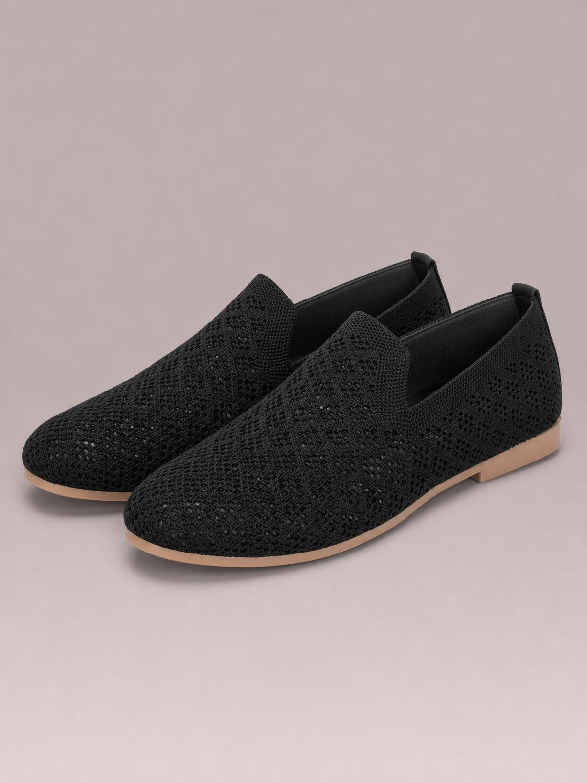 Black mesh round-toe flat slip-ons feature a breathable textured upper, easy slip-on construction, and low tan rubber soles.