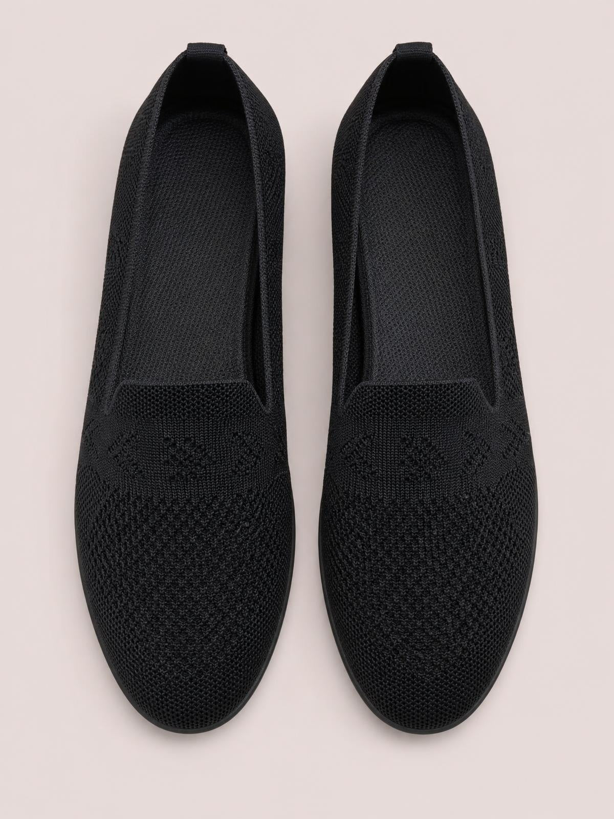Pair of black mesh round-toe flat slip-ons with woven uppers, streamlined silhouettes, and low rubber soles shown from above.