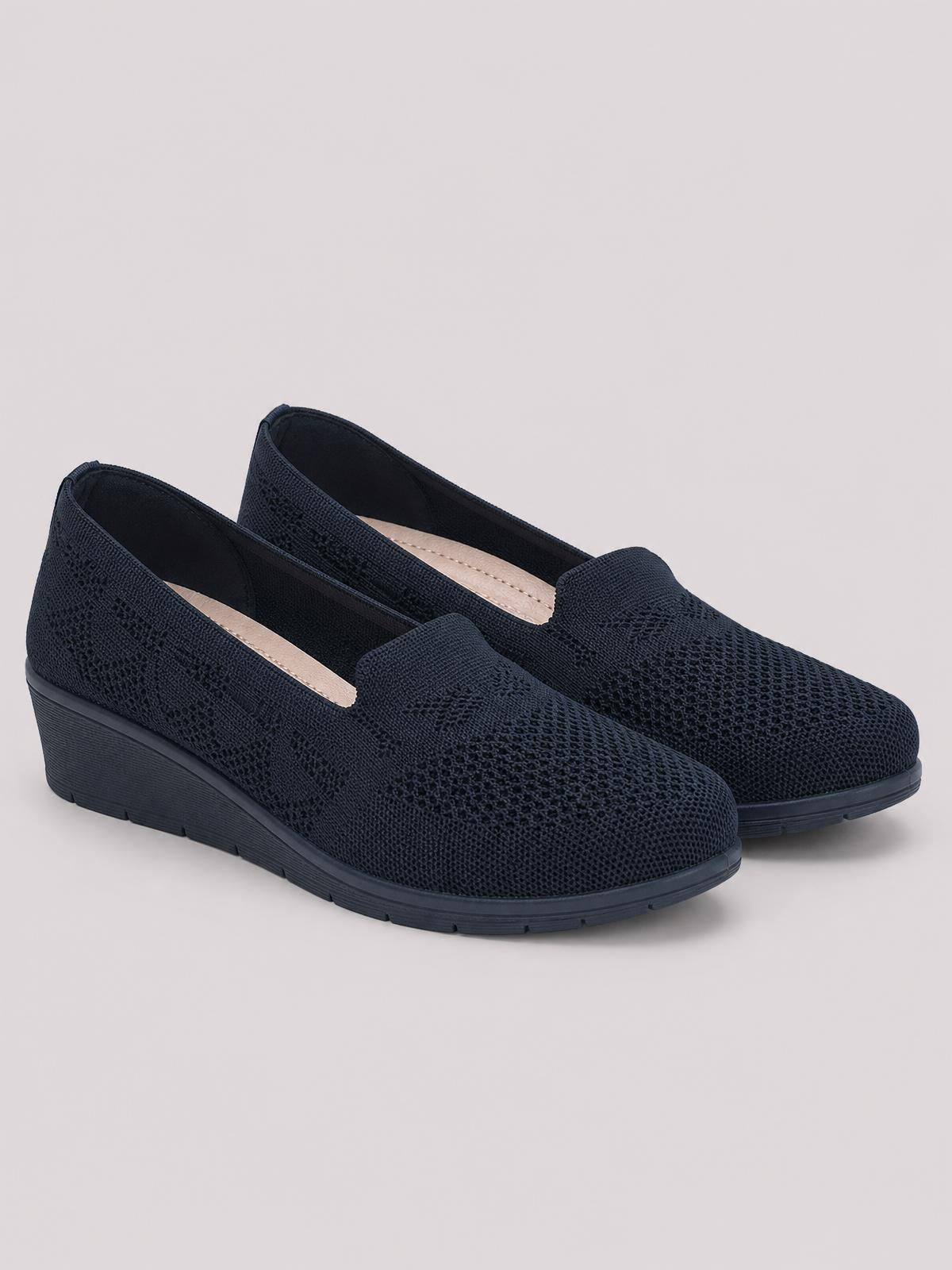 Black mesh round-toe slip-on shoes with textured uppers, low wedge-shaped rubber soles, and a streamlined silhouette.