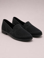 A pair of black mesh round-toe flat slip-ons features textured uppers, low-cut openings, and sturdy rubber soles.