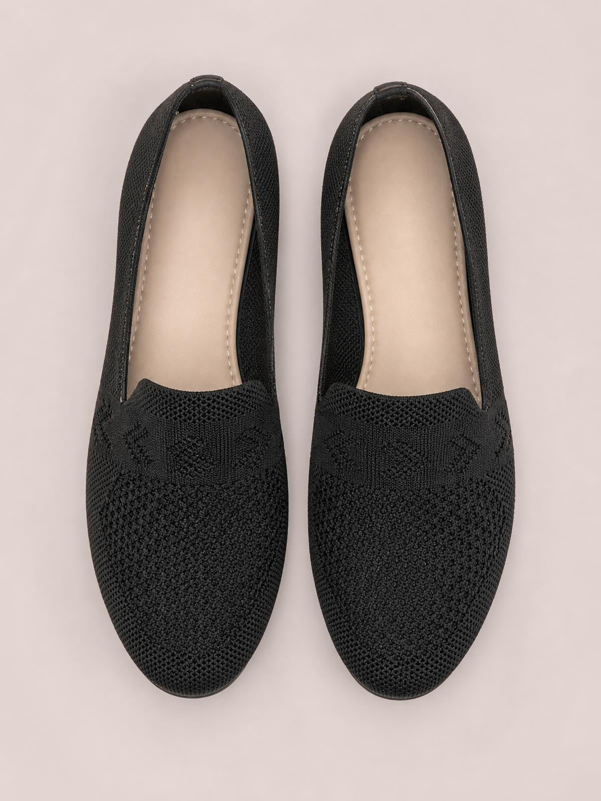 Black mesh round-toe flat slip-on shoes with a textured knit upper, low-profile silhouette, and stitched beige insoles.