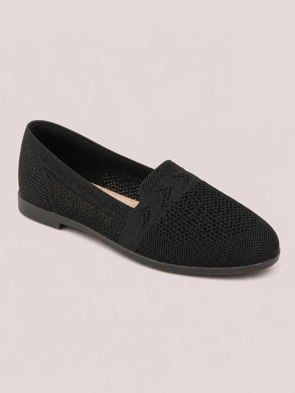 Black mesh round-toe flat slip-on shoe featuring a textured upper, open slip-on design, and a low-profile rubber sole.