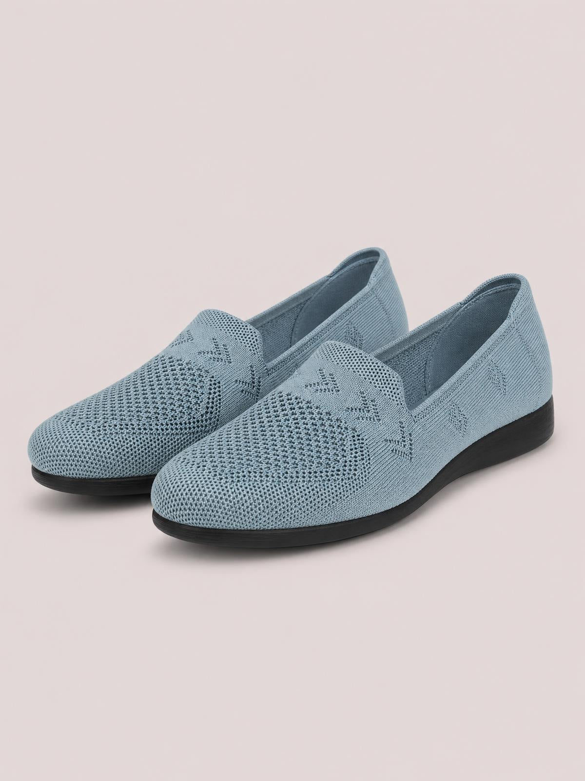 Blue mesh round-toe flat slip-on shoes with a textured knit upper, open ankle design, and black rubber soles.