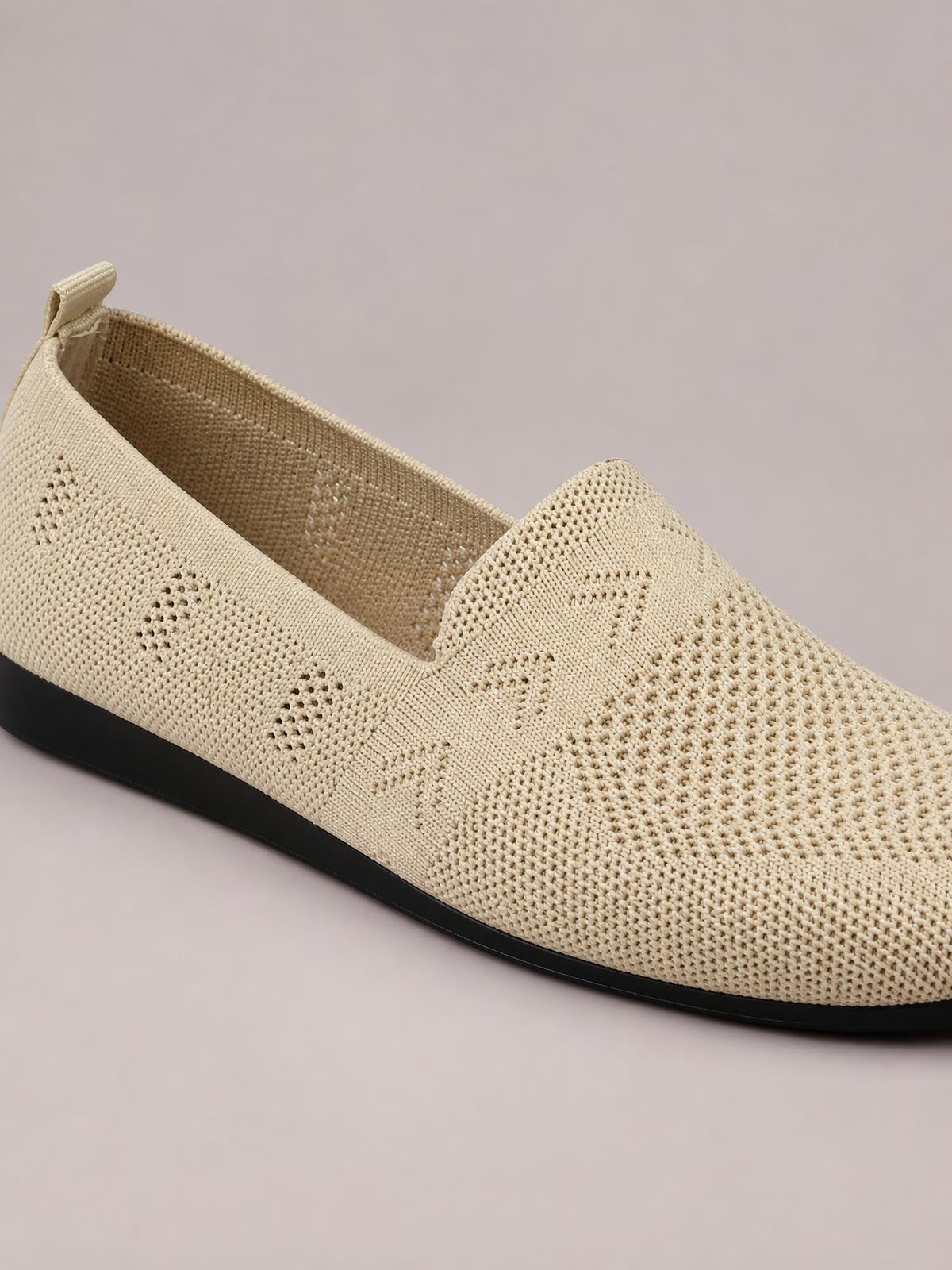 Beige mesh round-toe flat slip-on shoe with a textured woven upper, elasticized opening, and contrasting black rubber sole.