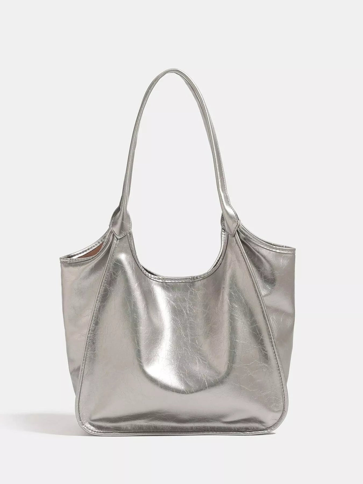 Metallic silver PU leather tote bag with a medium slouchy silhouette, long shoulder strap, open top, and neatly stitched curved seams.
