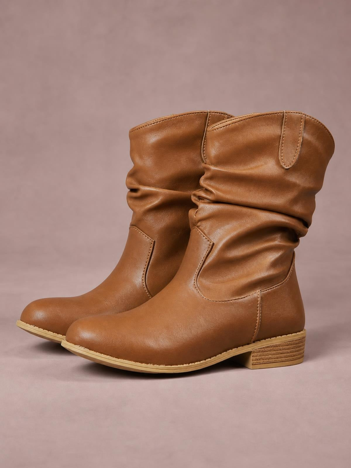 Brown mid-calf Western boots in PU leather feature slouchy shafts, rounded toes, stitched panels, stacked block heels, and rubber soles.