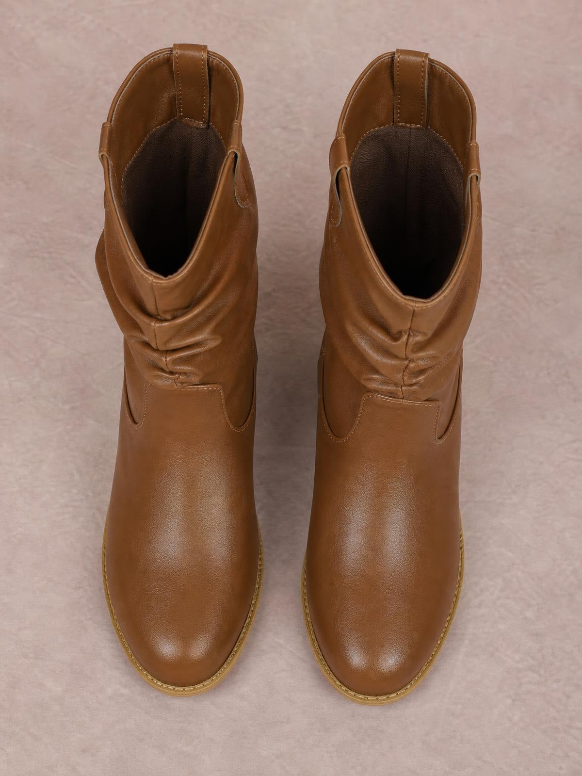 Pair of brown PU leather mid-calf Western boots with rounded toes, ruched shafts, pull tabs, stitched panels, and smooth slip-on construction.