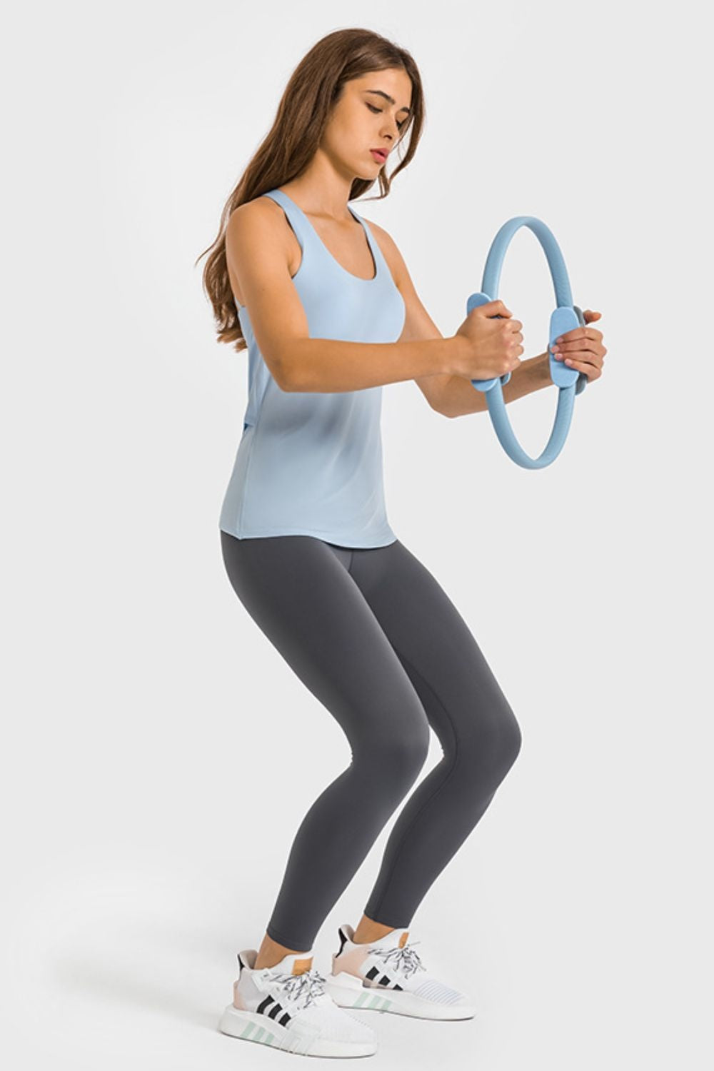 A model bends her knees while wearing black high-waist ankle-length yoga leggings with a sleek, highly stretchy fitted silhouette and clean construction.